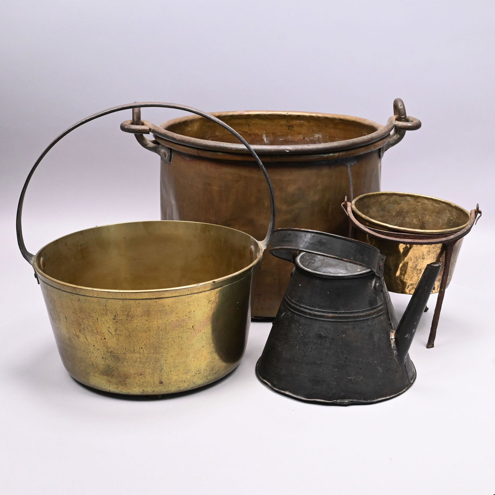Four Brass, Wrought-Iron and Tin Kitchen Kettles: Four Brass, Wrought-Iron and Tin Kitchen Kettles, Nineteenth Century. Comprising a brass kettle with riveted side, wrought-iron bail handle; a brass kettle with fixed steel handle, "MICHAEL DAVIS" lab