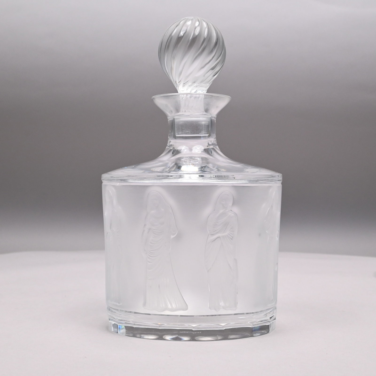 Lalique France 'Femmes Antiques' Glass Decanter: Lalique France 'Femmes Antiques' Colorless and Frosted Glass Decanter and Swirled Stopper, Before 1978. Acid etched "Lalique/ France" without the registered trademark symbol (R). H: 9.5 in., W: 5.125 