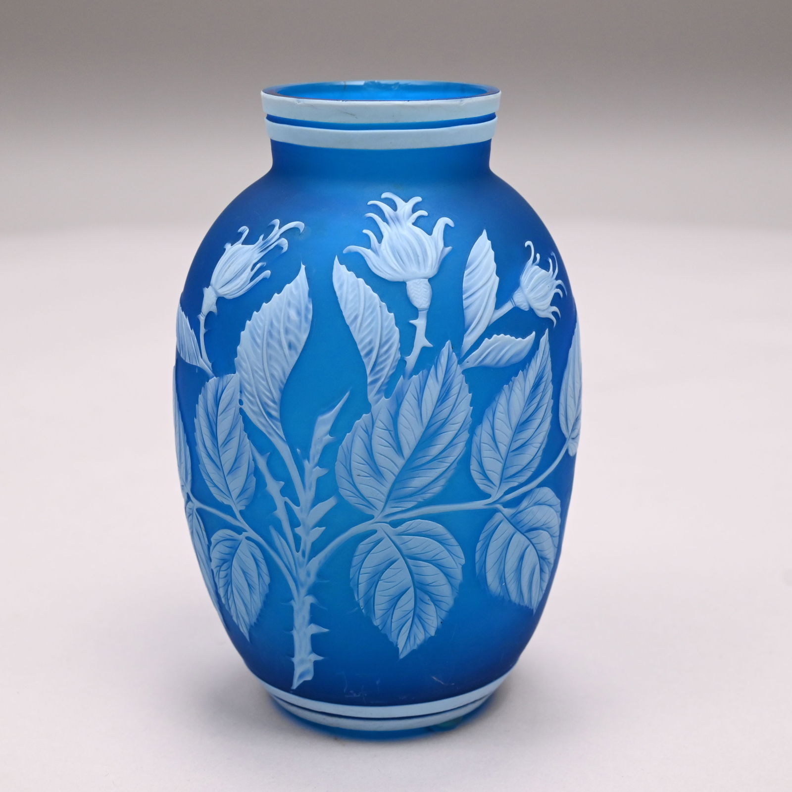 English Cameo Glass Vase, Attributed to Thomas Webb & Sons: English Cameo Glass Vase, Attributed to Thomas Webb & Sons, Stourbridge, 1880 - 1900. Overlaid in white glass and carved through to the Prussian blue glass with a spray of moss rose. H: 5.125 in., Dia