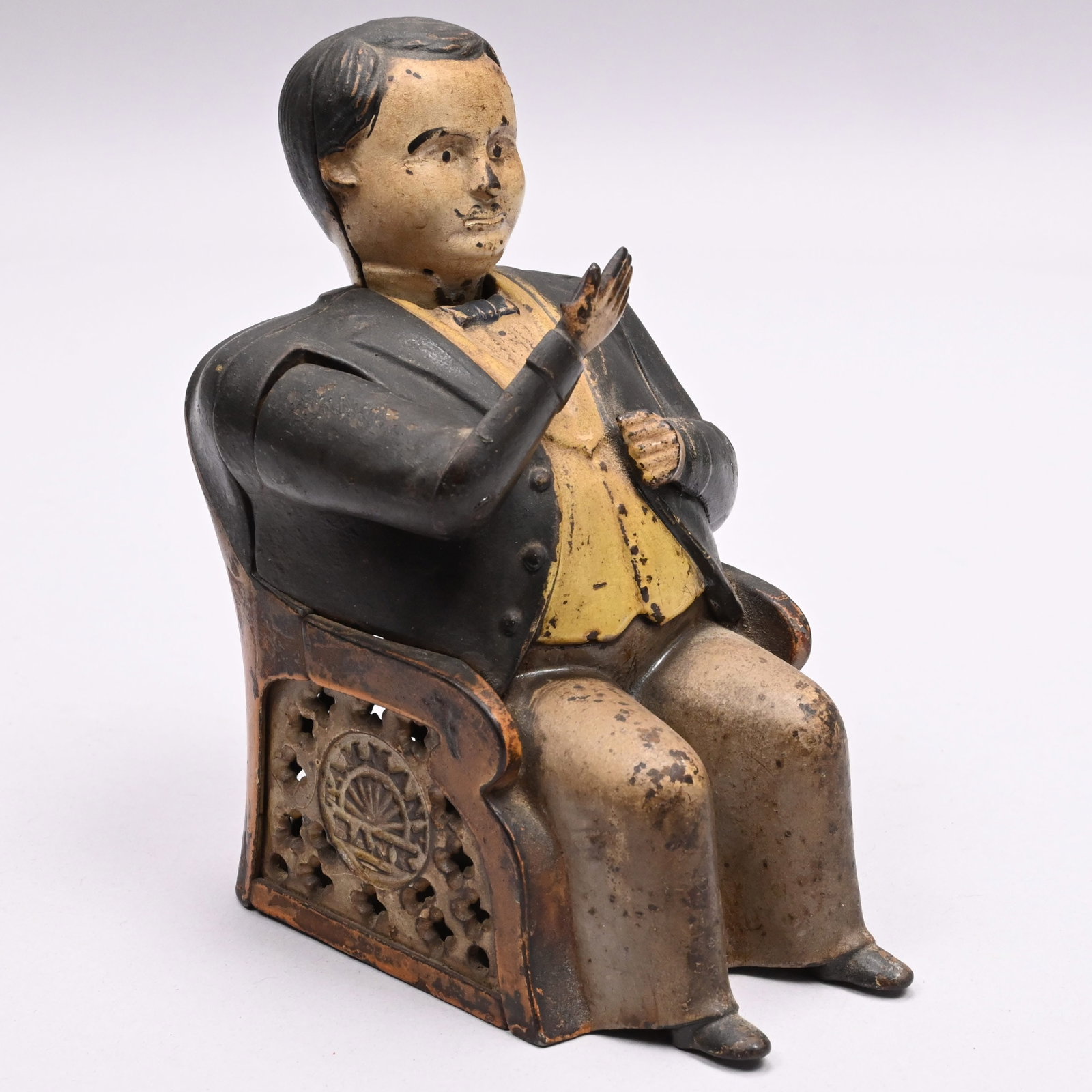 American Tammany Cast-Iron Mechanical Bank: American Tammany Cast-Iron Mechanical Bank, J. & E. Stevens Co., Cromwell, Connecticut, Circa 1875. Wearing a white shirt, yellow waist coat, tan pants, black bow tie and coat, the weight of a coin pl
