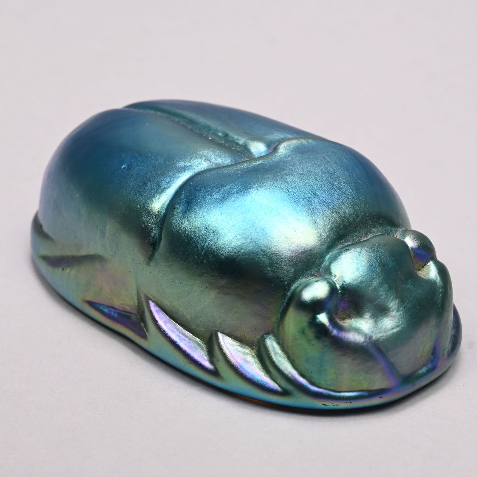 Art Glass Paperweight in the Form of a Scarab: Art Glass Paperweight in the Form of a Scarab, Twentieth Century. In iridescent blue glass, unmarked. H: 1.5 in., W: 4.875 in., D: 2.75 in.