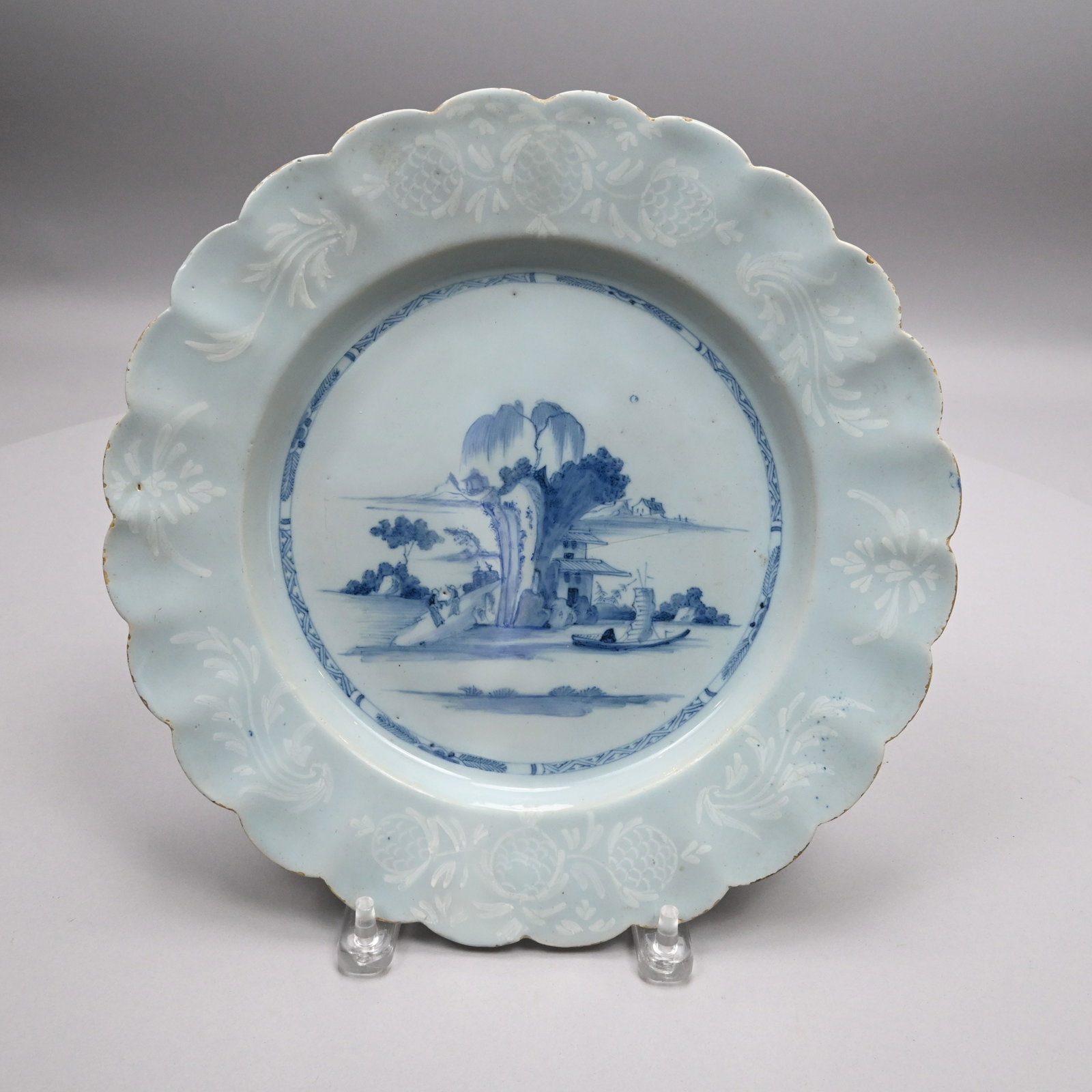 London or Bristol Delft Bianco-Sopra-Bianco Plate: London or Bristol Delft Bianco-Sopra-Bianco Plate, 1750 - 1760. Painted in the center with a chinoiserie view of a tall rock surmounted by a willow tree, flanked on one side by two figures conversing 
