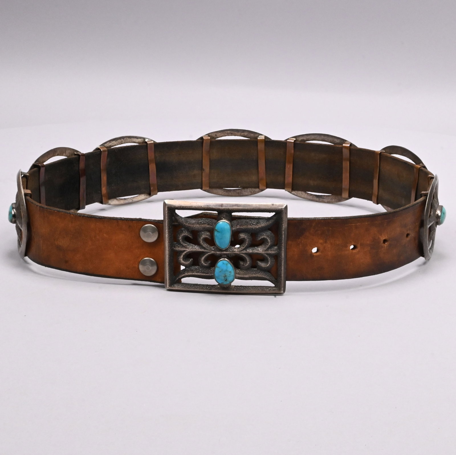 American Southwest Silver & Turquoise Concho Belt: American Southwest Silver, Turquoise and Leather Concho Belt. Set with seven oval conchos, each centered with a star and set with turquoise, the rectangular buckle with stylized scrolls and set with t