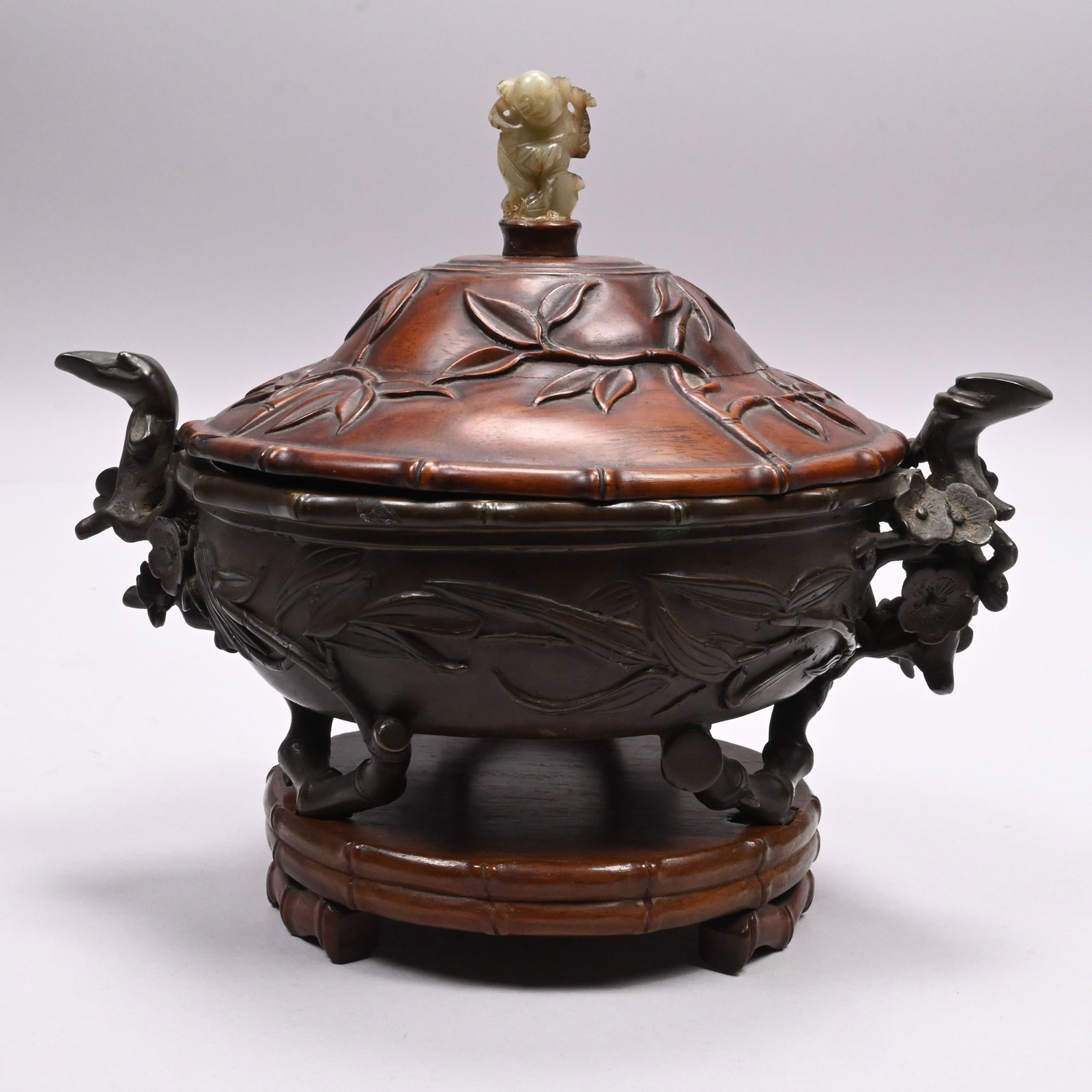 Chinese Bronze Bowl with Carved Hardwood Cover: Chinese Bronze Bowl with Carved Hardwood Cover. The bowl cast with flowering prunus branch handles, raised on three bamboo stem feet issuing leafy branches onto the sides, the cover carved with leafy 