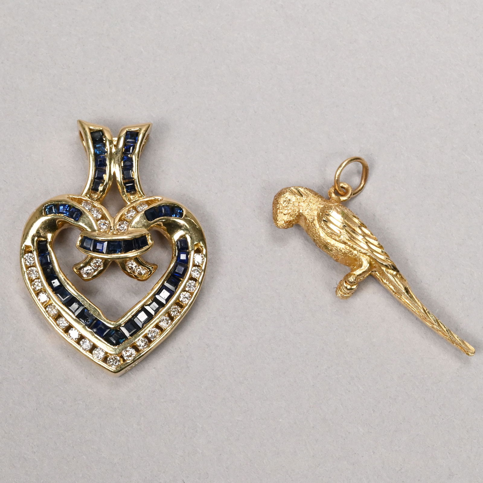 14k Gold & Sapphire Pendant Heart & a 14k Parrot: 14k Yellow Gold and Sapphire Pendant Heart and a 14k Yellow Gold Parrot. The pendant with channel-set sapphires and diamonds, maker's mark "ADD" and "14k"; the parrot unmarked but tested 14k.10g total