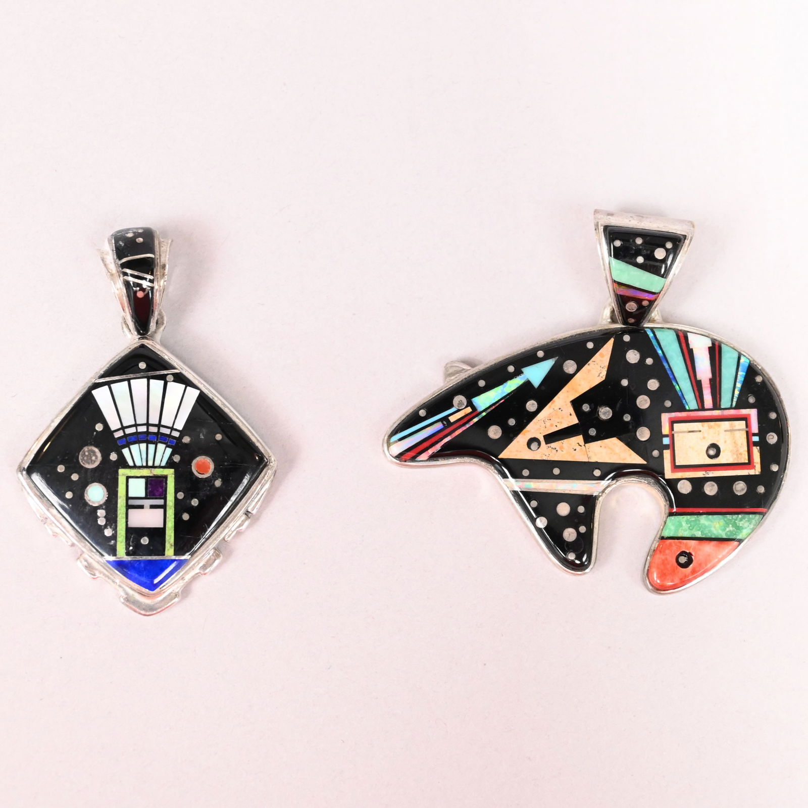 Two Navajo Silver Inlaid 'Night Sky' Pendants: Two Navajo Sterling Silver Inlaid Stone 'Night Sky' Pendants, Calvin Begay (Mexican, b. 1965). Comprising a bear and clasp inlaid in various geometric stones; and a diamond-shaped pendant inlaid with