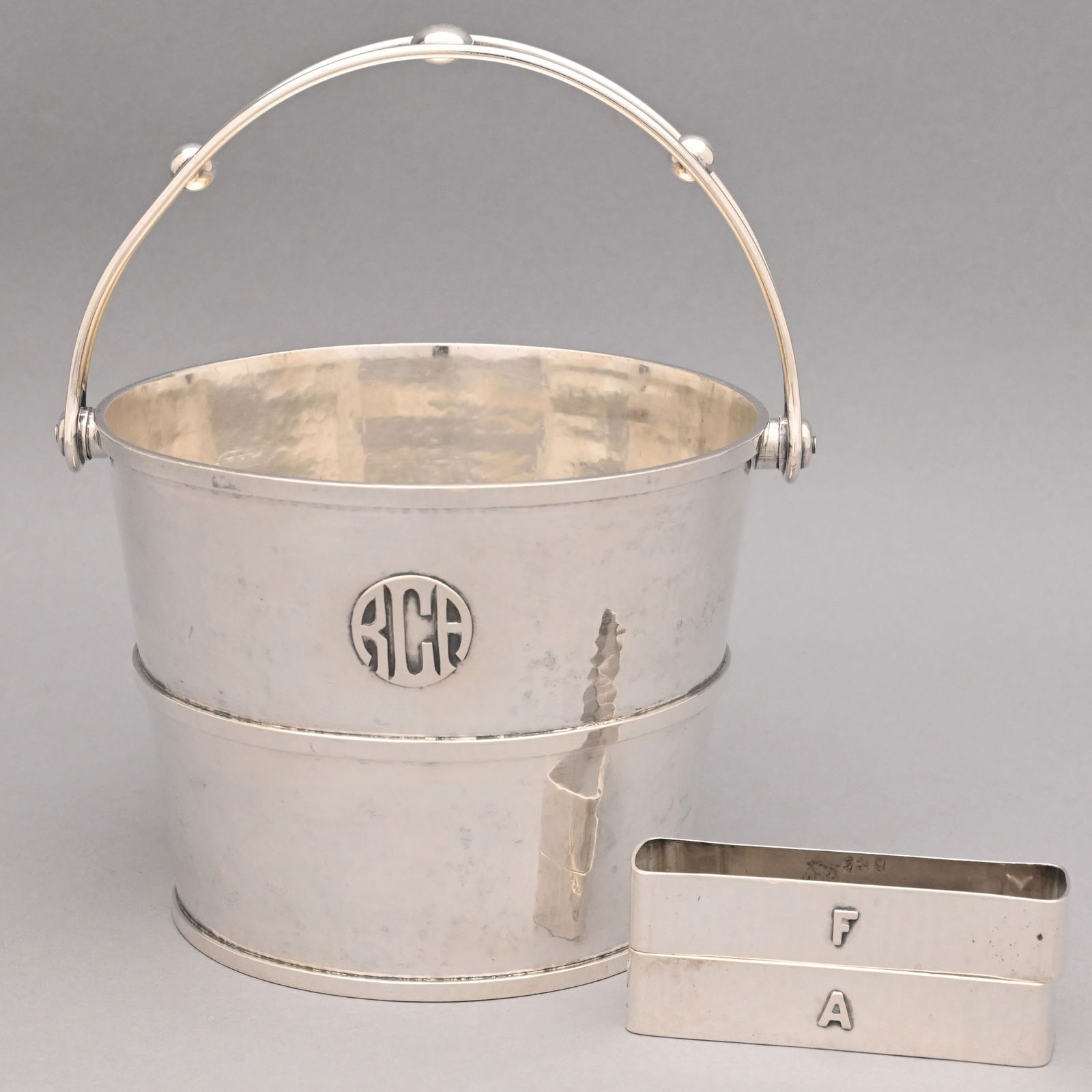 Arts & Crafts Silver Pail and Pair of Napkin Rings: American Arts & Crafts Hammered Sterling Silver Ice Pail and Pair of Napkin Rings, Lebolt & Co., Chicago, Illinois, 1908-1920. The pail applied on the front with the monogram "RCA," the open bail