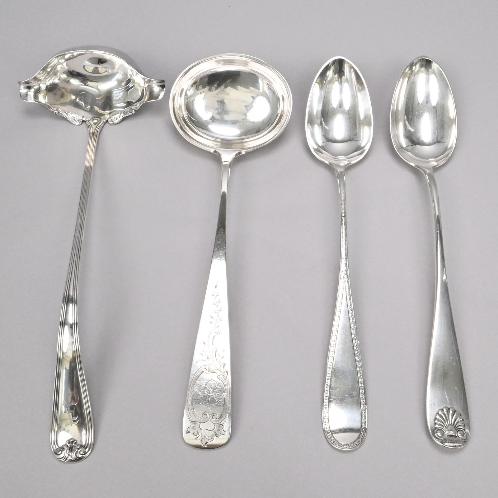 American & German Silver Ladle&Two Stuffing Spoons: German and American Silver Soup Ladles and Two American Dressing/ Stuffing Spoons. Comprising a German 12.375-inch soup ladle, engraved with a scroll-edged ruffled cartouche suspending vines,