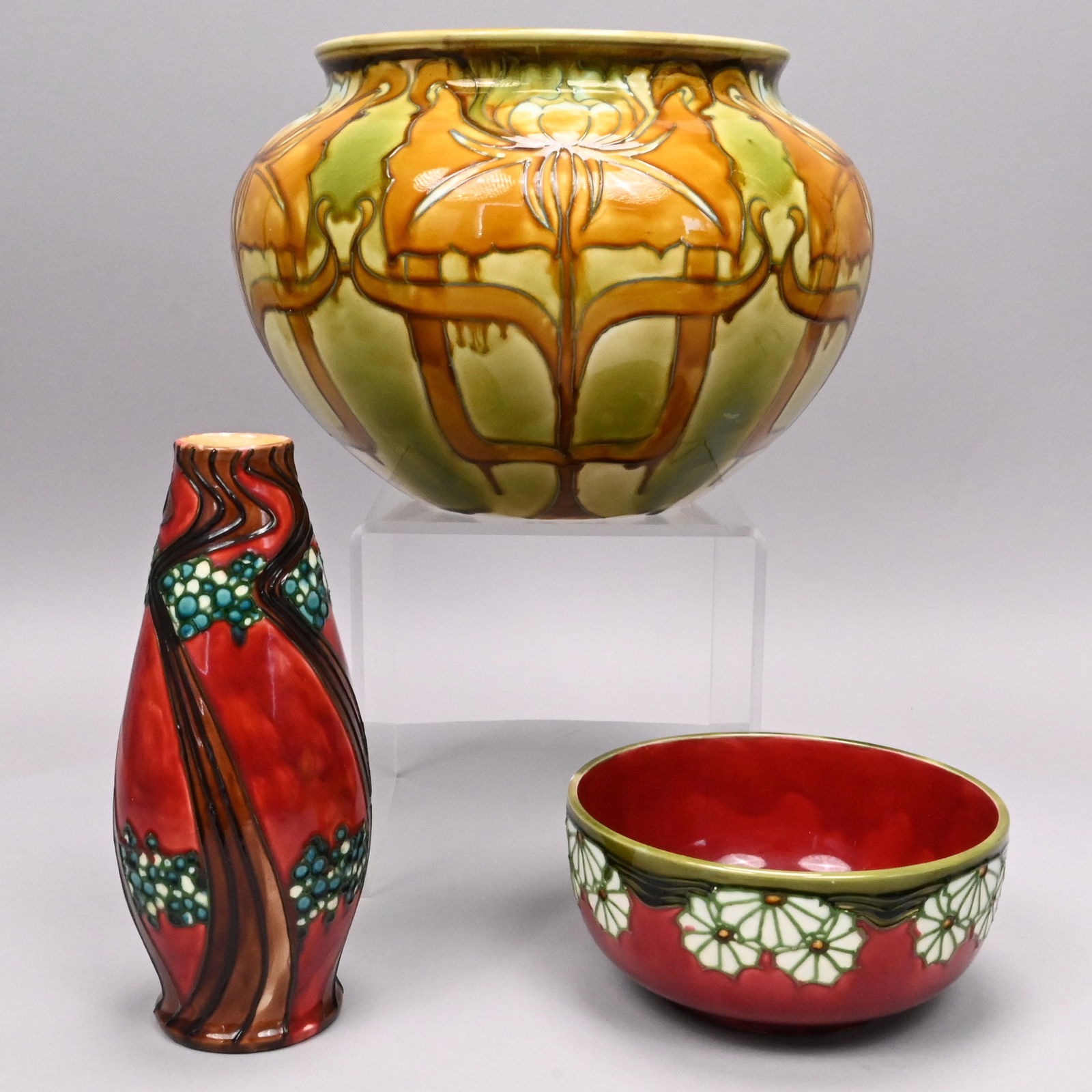 Three Mintons Ltd. "Secessionist" Wares: Three Mintons Ltd. "Secessionist" Wares, Circa 1907. Each tube-lined in patterns of stylized flowers and comprising a red-ground 9.125-inch vase, marked "No 9," a red-ground 7.125-inch bowl, marked