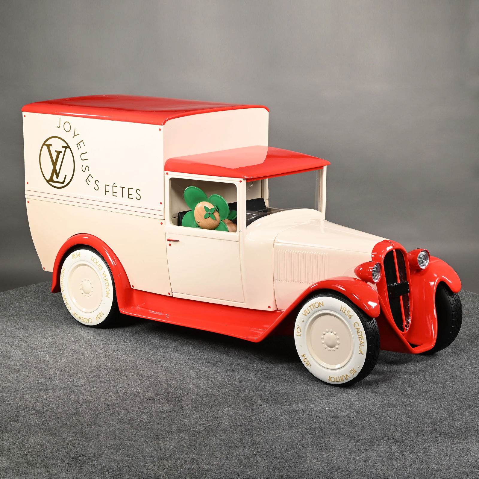 Louis Vuitton Camionnette (Van) Store Display: Louis Vuitton Camionnette (Delivery Van) Store Display. In red and white fiberglass, inscribed on each side "JOYEUSES FETES" (Joyous Holidays) with the "LV" monogram within a circle in gold, a green a