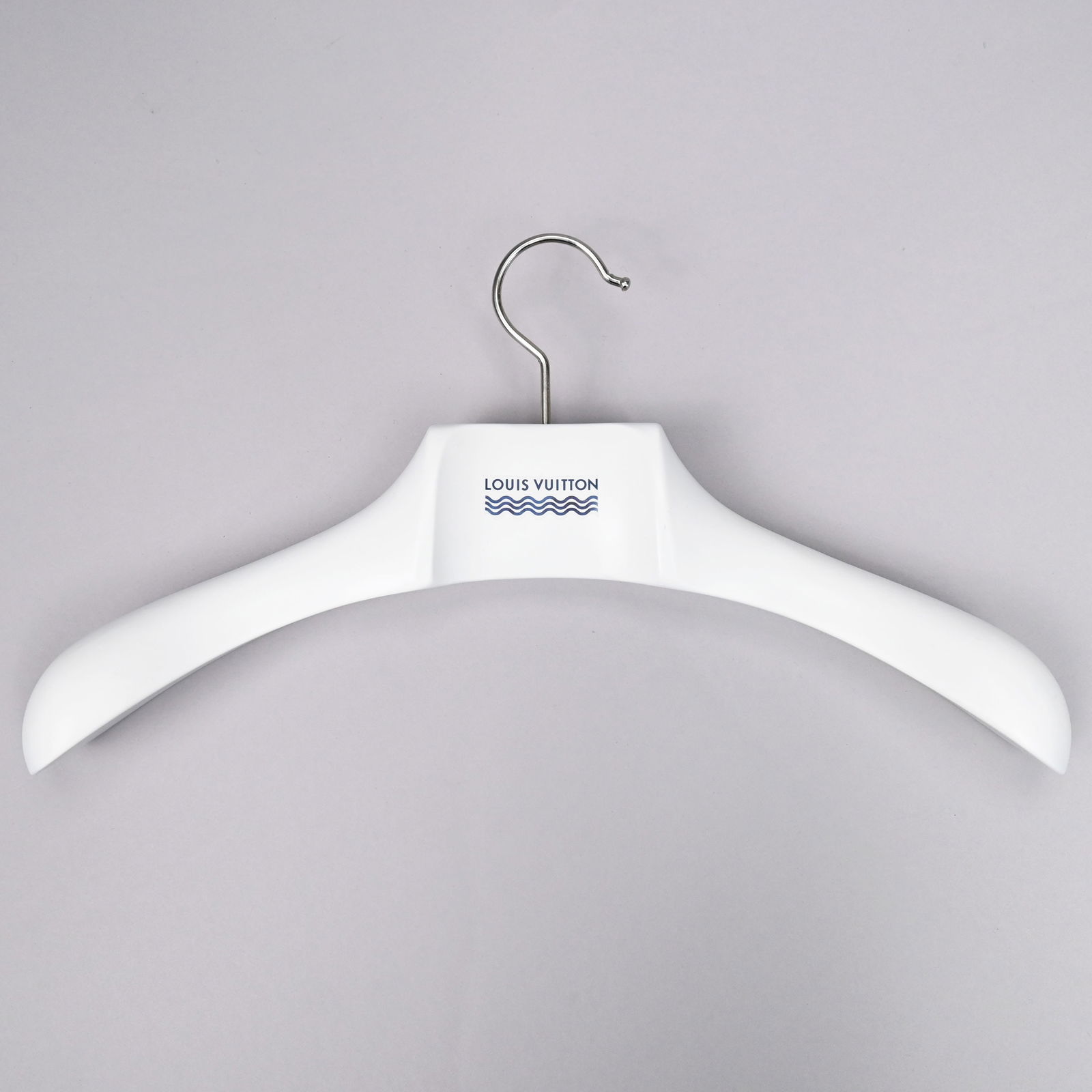 Twenty-Nine Louis Vuitton Coat Hangers: Twenty-Nine Louis Vuitton White Resin and Brass Coat Hangers, 21st Century. Comprising seven hangers with clips and twelve plain hangers, each printed "LOUIS VUITTON" above three waves in blue