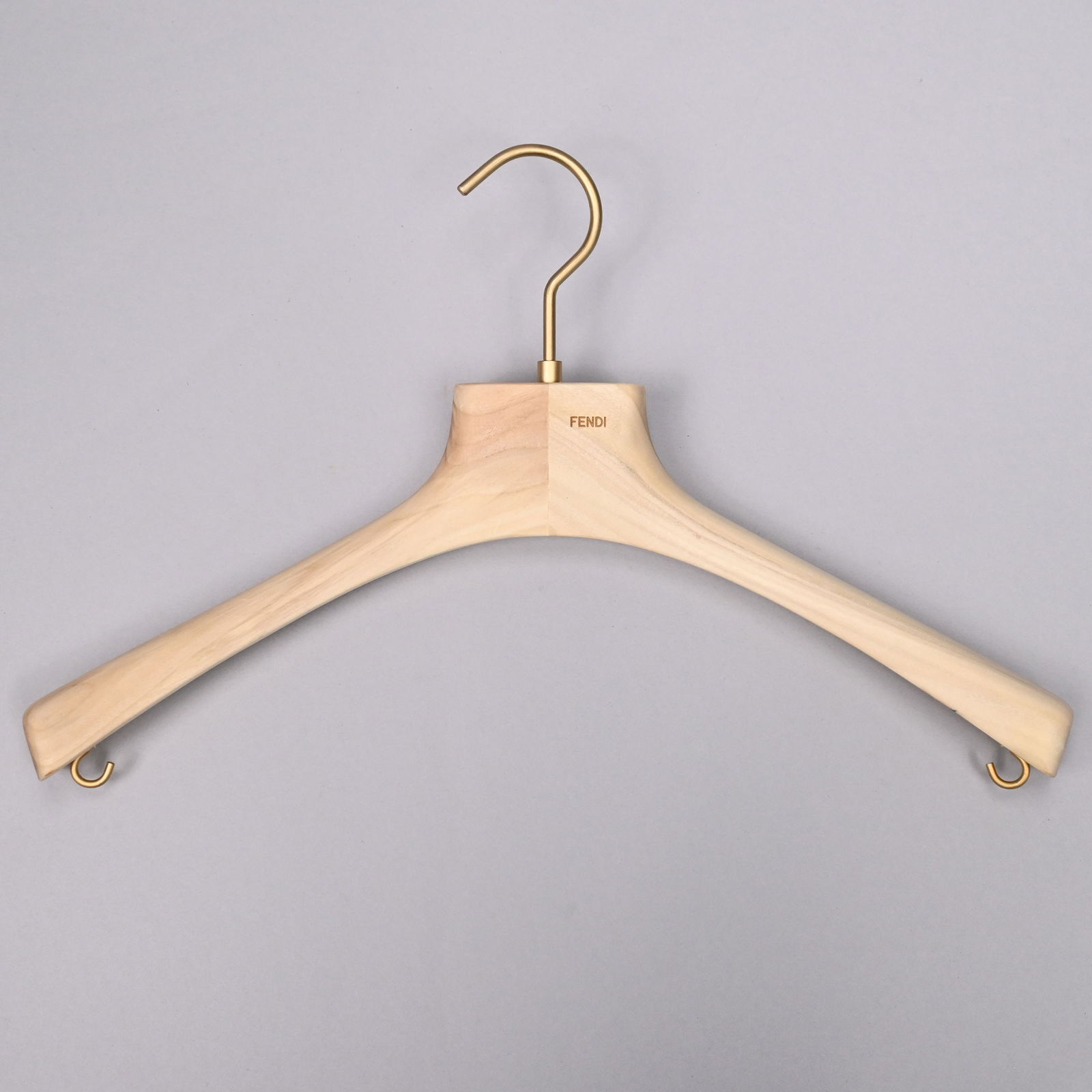 Thirty-Nine Hardwood Fendi Hangers: Thirty-Nine Hardwood Fendi Hangers, 21st Century. Each stamped "FENDI" in gold letters on one side, with gold-colored hook and strap hooks.H: 11 in., W: 15.625 in., D: 2 in.
