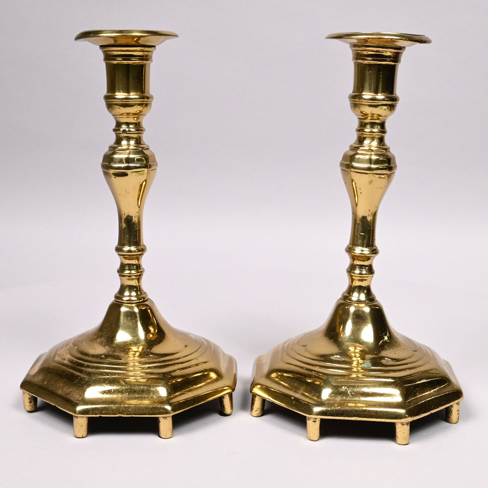 Pair of Russian Brass Shabbat Candlesticks: Pair of Russian Brass Shabbat/ Sabbath Candlesticks, Late 18th-Early 19th Century. Each octagonal tapered and knopped standard ending in a matching nozzle with drip-pan, the octagonal turned base on