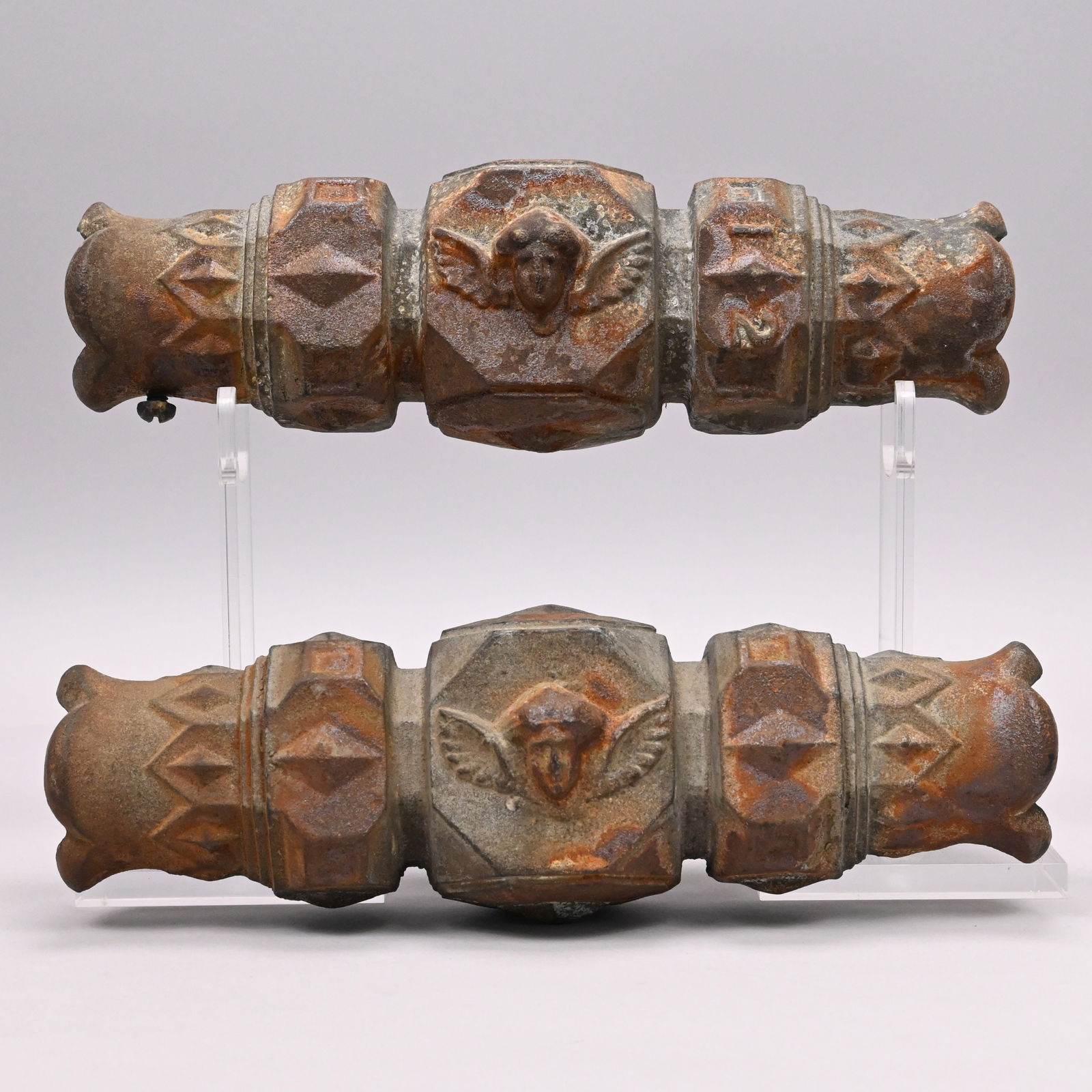 Pair of Cast Zinc Architectural Elements: Pair of Cast Zinc Architectural Elements, Late 19th Century. Composed of geometric-shaped sections, the middle section cast on two sides with a winged female mask.H: 12.625 in., W: 4 in., D: 4.5