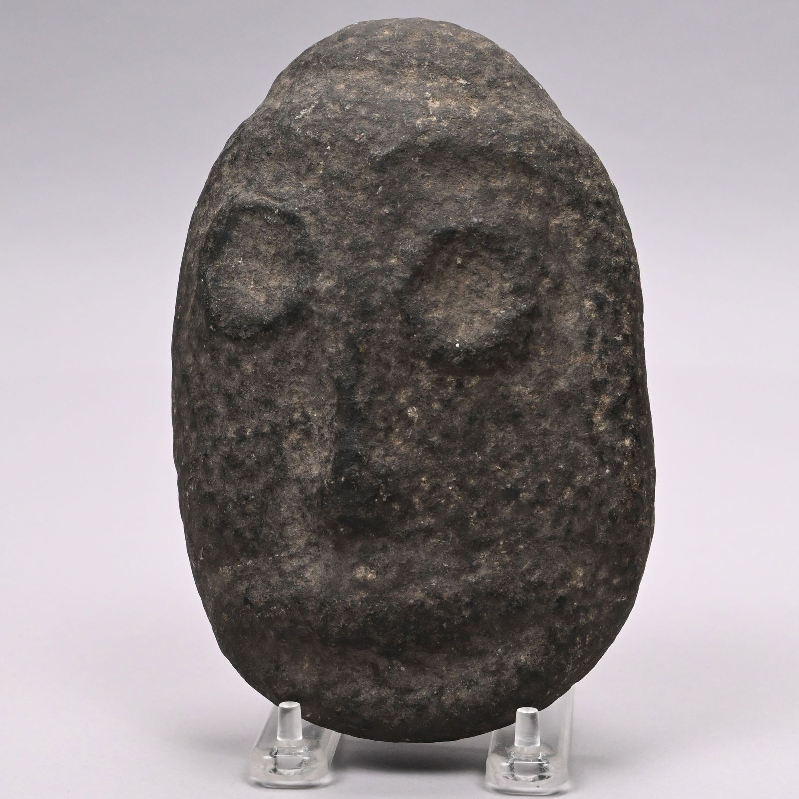 Ancient Carved Stone Mask: Ancient Carved Stone Mask, Possibly Mesoamerican Cultures or Neolithic Period. Carved with circular recessed eyes, a straight nose and full lips.H: 7 in., W: 4.625 in., D: 2.125 in.