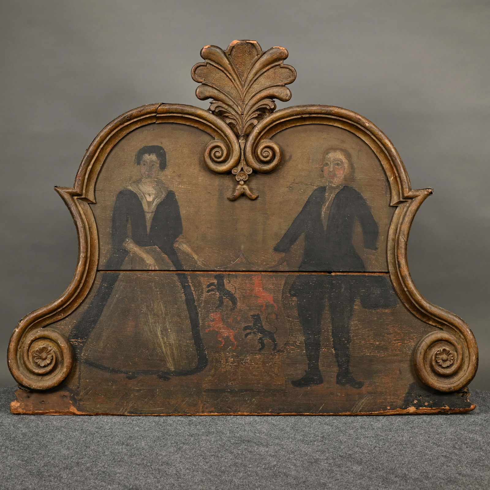 Continental Carved & Painted Coat of Arms: Continental Carved & Painted Coat of Arms with Figures, 18th Century. The panel with double arched molded top with volutes, centering a carved plume, the paint decorated coat of arms centered between