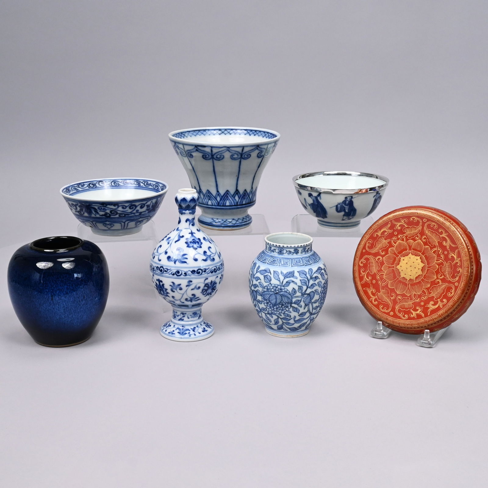 Seven Chinese & Japanese Porcelain&Stoneware Items: Seven Chinese and Japanese Glazed Porcelain and Stoneware Articles. Comprising a blue and white 'Eight Immortals' bowl applied with a silvered-metal rim, Kangxi mark in underglaze-blue; a vase stand g