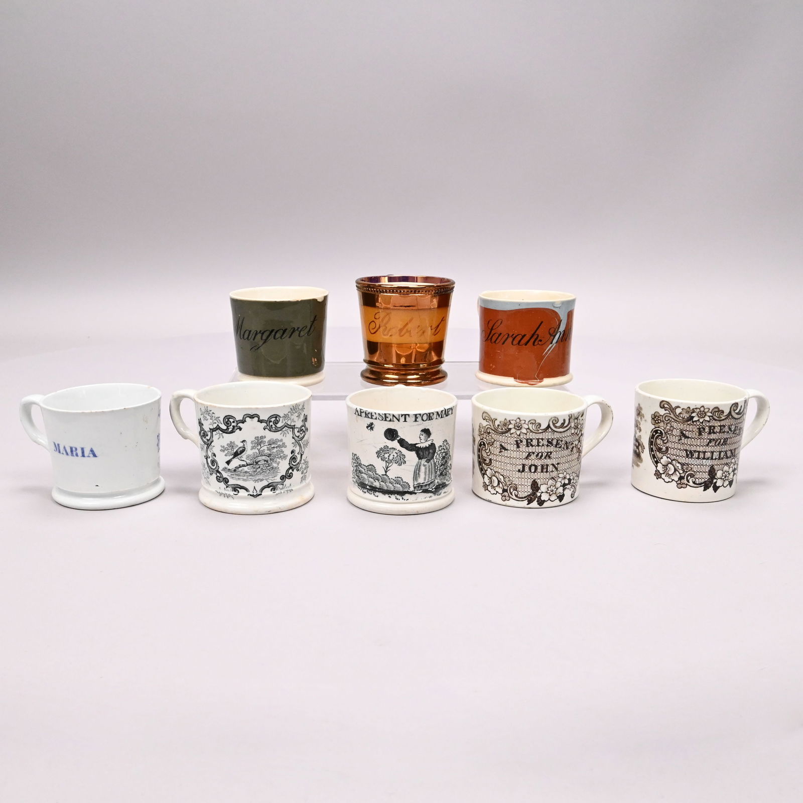Eight Staffordshire Transfer-Printed Child's Mugs: Eight Staffordshire Transfer-Printed Named Children's Mugs, 1800-1850. Comprising a creamware mug for "Margaret" slip-banded in grey, a creamware mug for "Sarah Ann" slip-banded in blue and rust, a