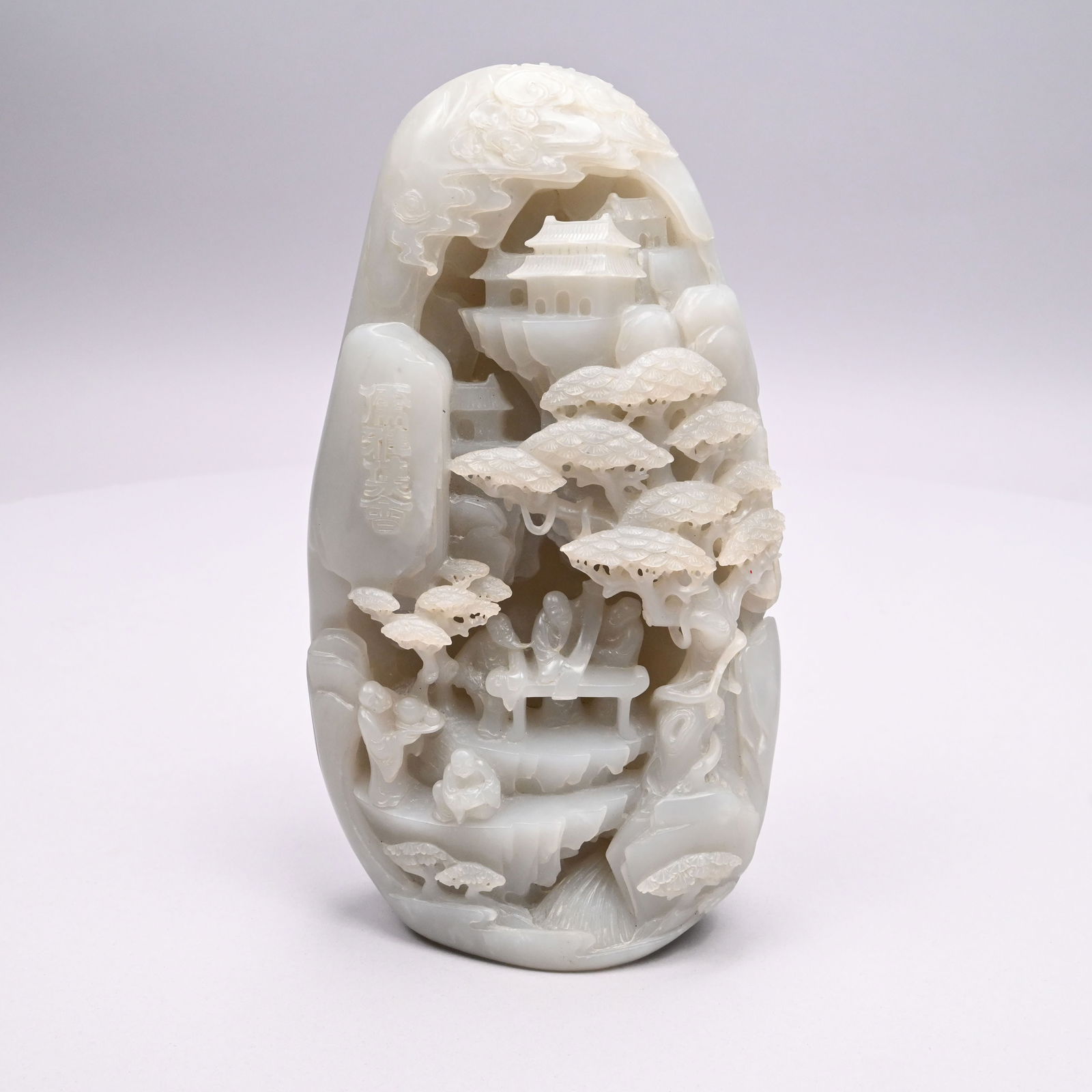 Chinese Carved Pale Grey Figural Jade Mountain: Chinese Carved Pale Grey Figural Jade Mountain. Carved on one side with a grotto enclosing three scholars at an altar table observing an unrolled scroll, a figure seated on a cliff step below and anot