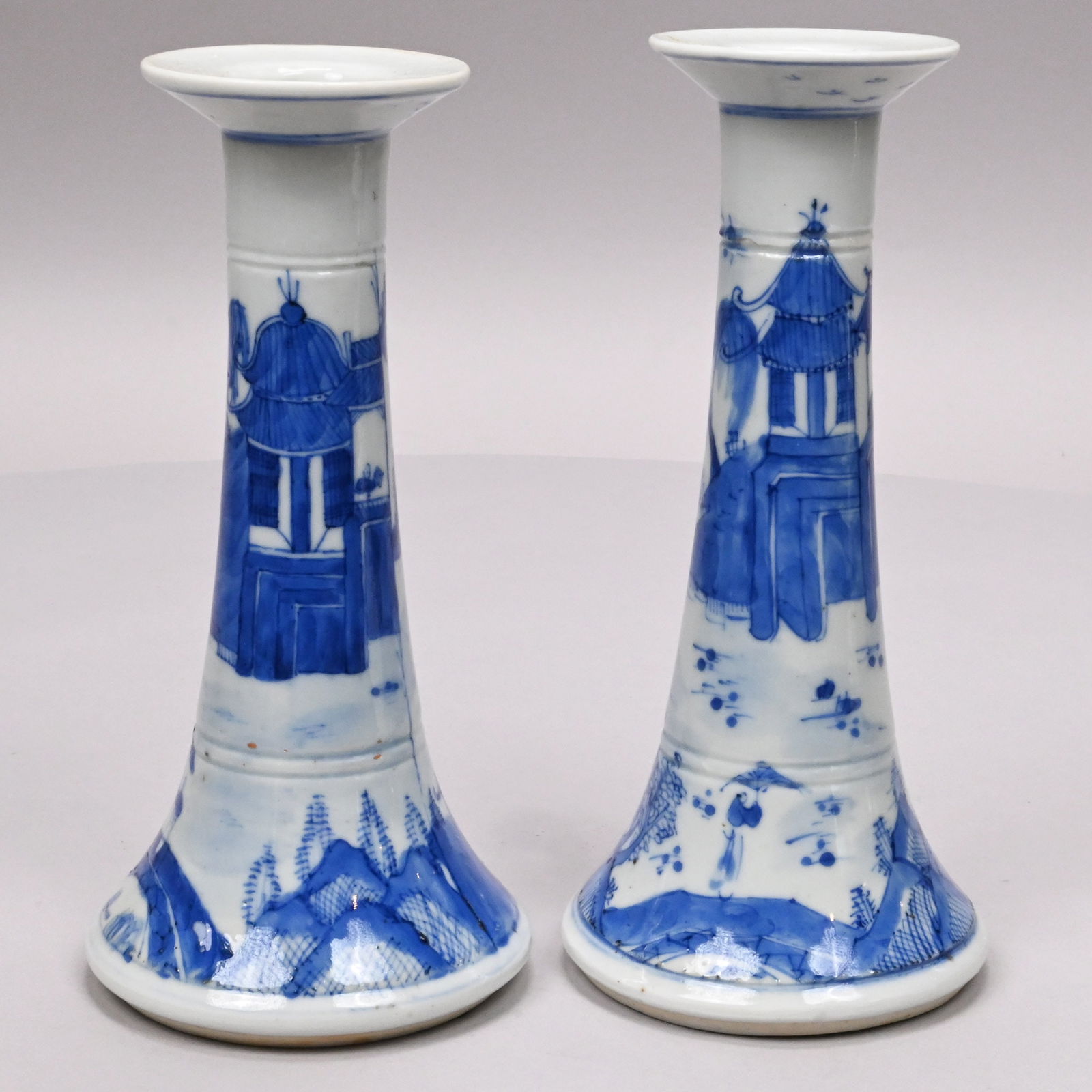Pair Chinese Export Porcelain Nanking Candlesticks: Pair of Chinese Export Porcelain Nanking Blue and White Candlesticks, Circa 1860. Each painted with an estuary landscape depicting several teahouses, a scholar seated in a teahouse, a figure with