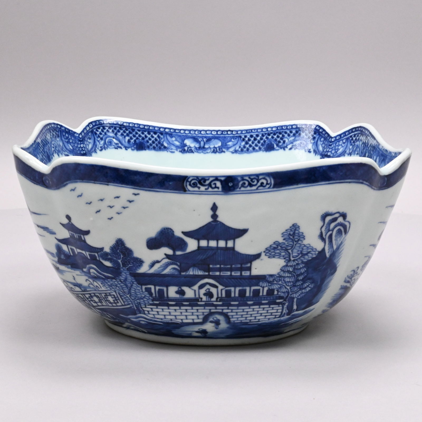 Chinese Export Porcelain Nanking Cut-Corner Bowl: Chinese Export Porcelain Nanking Blue and White Cut-Corner Salad Bowl, Circa 1770. Painted on two sides with a view of two figures inside a temple, and two figures below standing on a path leading to