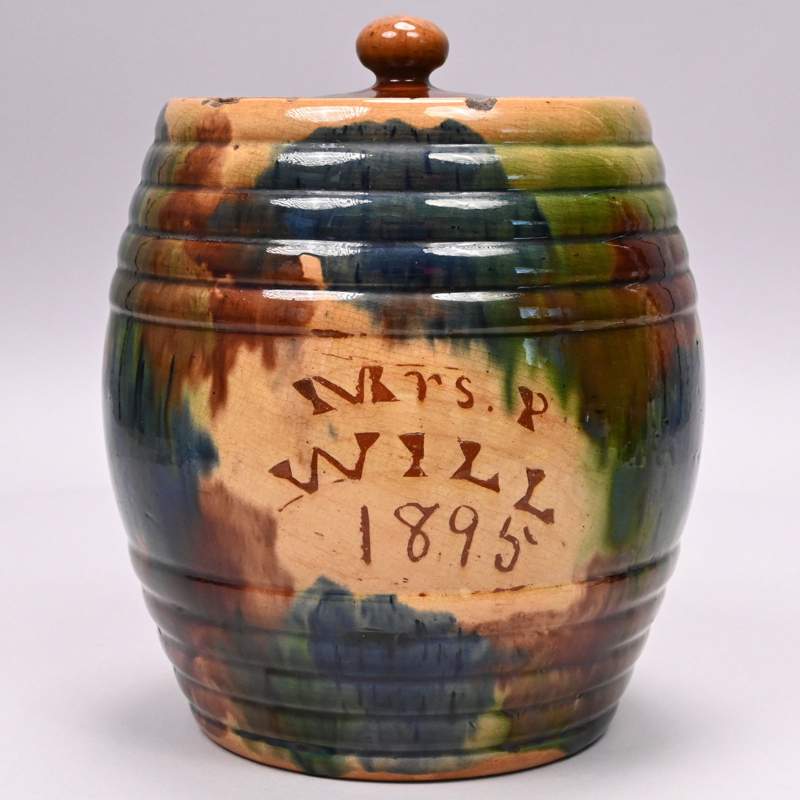 Scottish Glazed Yellow Ware Biscuit Barrel: Scottish Glazed Yellow Ware Biscuit Barrel, Seaton Pottery, Aberdeen, Scotland, Dated 1895. Possibly commemorating a marriage, the barrel and lid covered in patches of blue, green and brown slip,