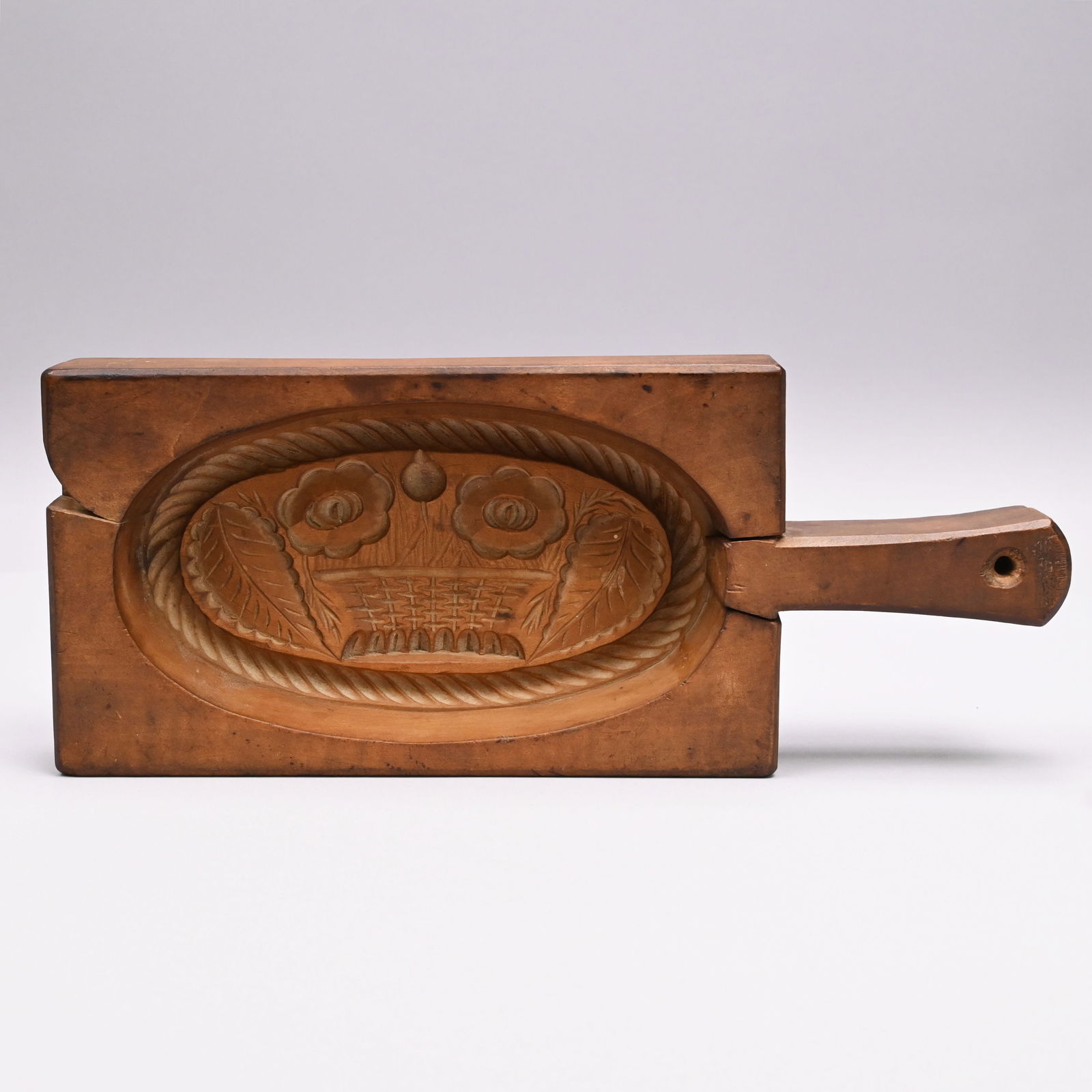 Carved Wooden Cake Board with Swing Handle: Carved Wooden Cake Board with Swing and Stationary Handle, Nineteenth Century. The top of the rectangular board with swing handle and the bottom handle stationary, carved on the interior with an oval