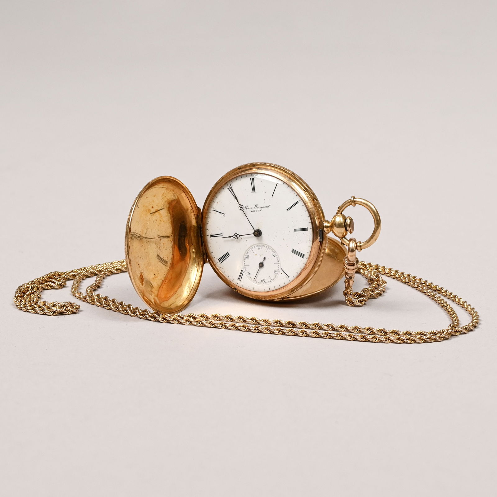 14k Gold Gent's Pocketwatch with 10k Chain: 14k Yellow Gold Gentleman's Hunter Case Pocketwatch, Marc Pergaud; with 10k Yellow Gold Chain. The front and back of the case engraved with a leafy spray within scrolls, flower and leaves, the white e