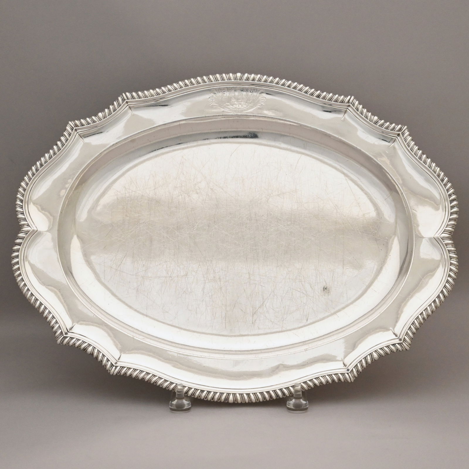 George III Sterling Silver Armorial Platter,London: George III Sterling Silver Armorial Oval Meat Platter, John Parker I and Edward Wakelin, London, 1766. The shaped rim within a conforming gadrooned edge, engraved on the rim with the armorial within l