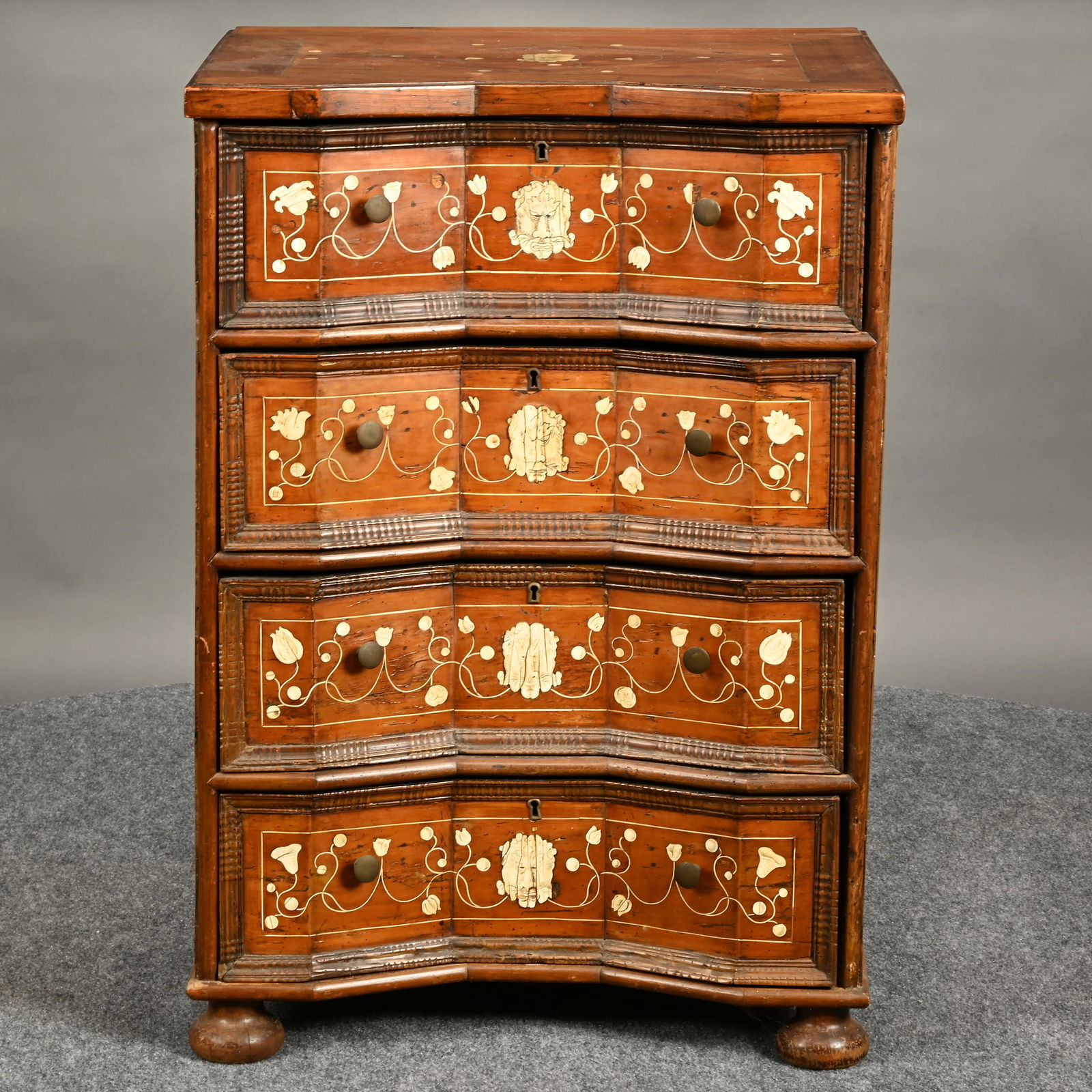 18th C. Italian Bone Inlaid Fruitwood Commode: 18th Century Italian Bone Inlaid Fruitwood Commode. The oblong top with applied edge and inset front, with diamond inlay centering a scrimshaw decorated grotesque face encircled with flower head,