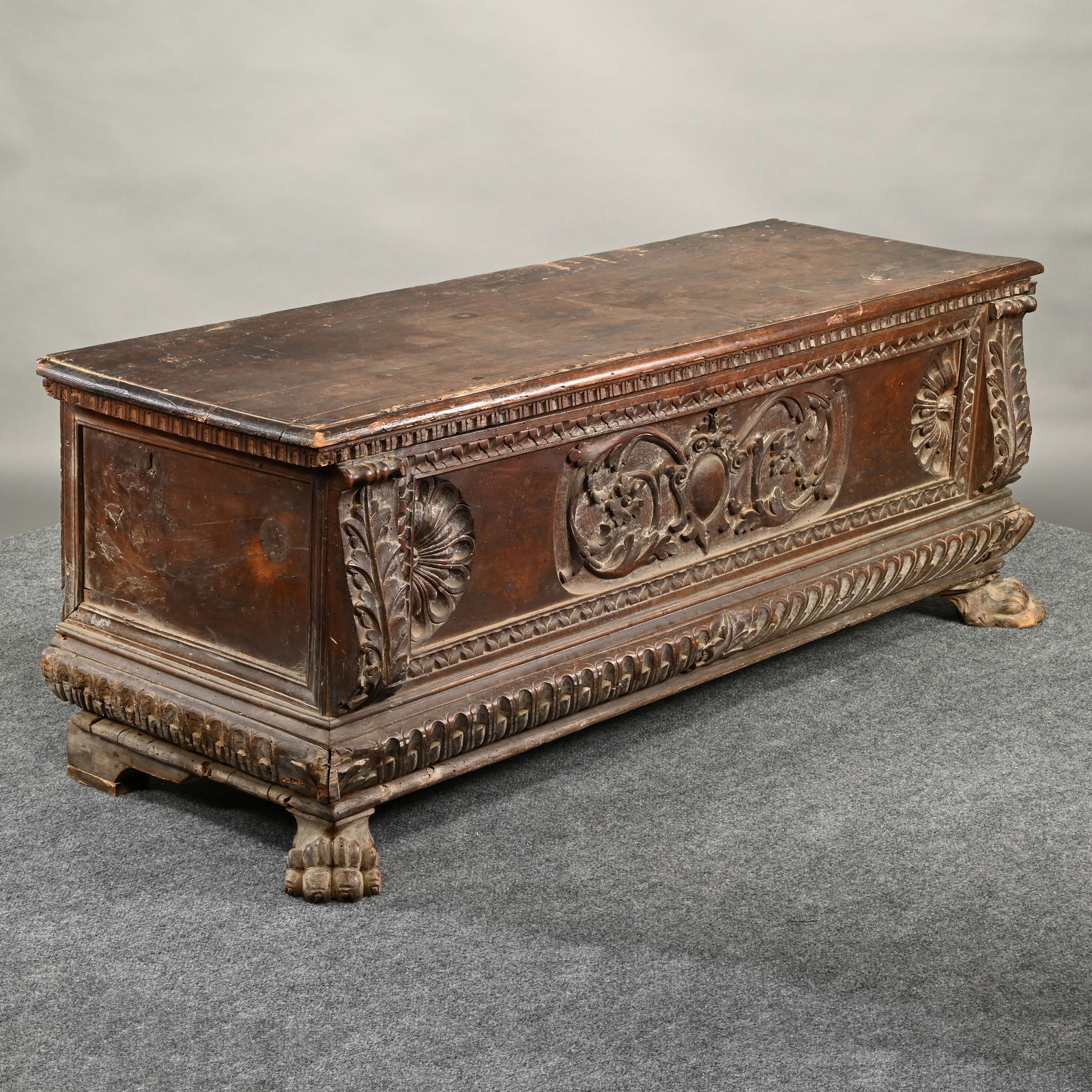 Italian Baroque Carved Walnut Cassone: Italian Baroque Carved Walnut Cassone, 17th/18th Century. The oblong hinge top with dental molded edge and iron hinges, opening to a storage compartment with till, above a facade, with central carved