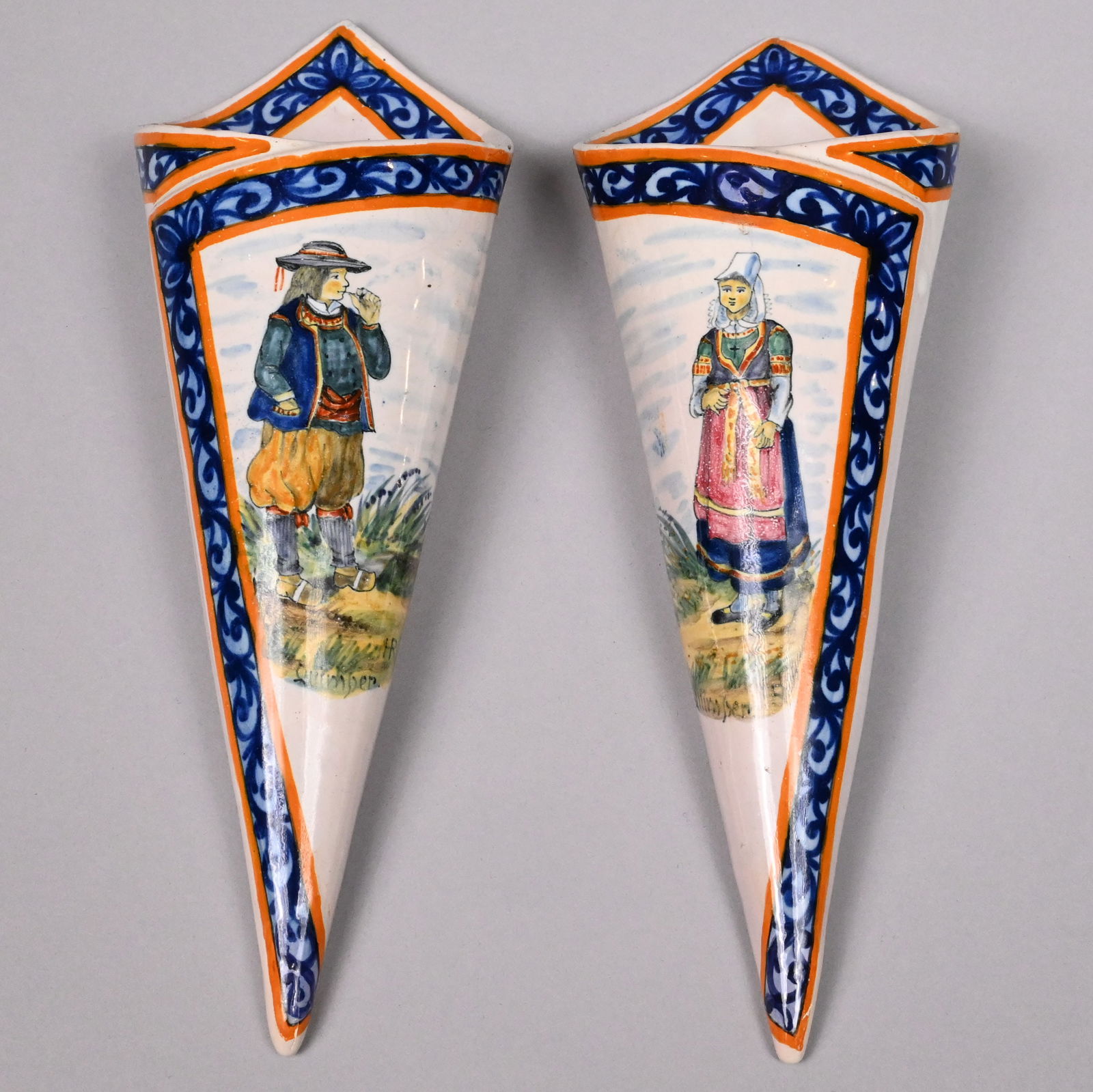 Pair of Quimper Faience Wall Pockets, Henriot: Pair of Quimper Faience Wall Pocket Vases, Henriot Factory, 1895-1922. Each of cone shape, painted with a Breton woman and a man in a landscape, within orange-edged cobalt and light blue scroll