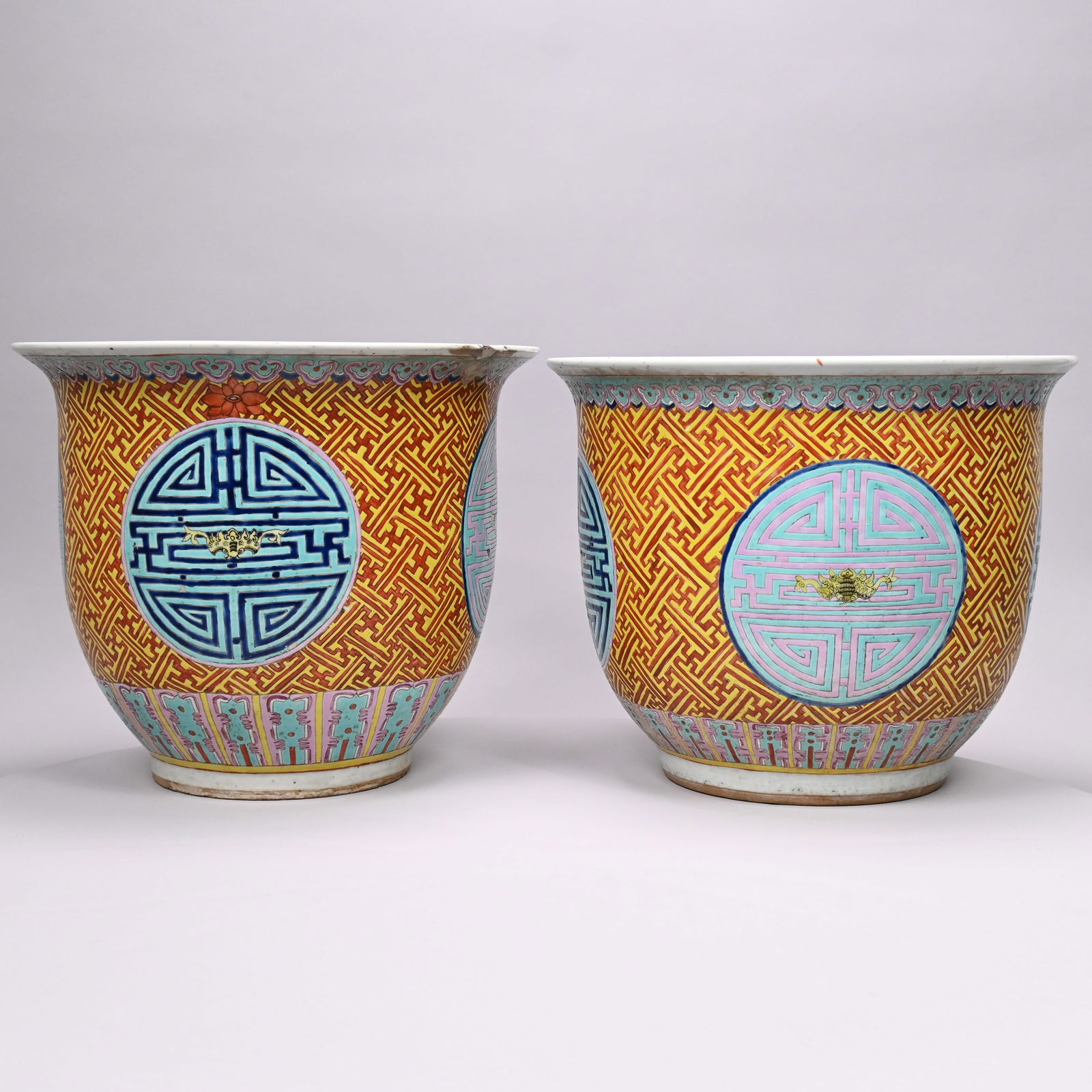 Two Nearly Identical Chinese Porcelain Jardinieres: Two Nearly Identical Chinese Porcelain Jardinieres, Late 19th-Early 20th Century. Each painted in a red and yellow trellis diaperwork pattern reserved with four Shou (longevity) crests in shades of