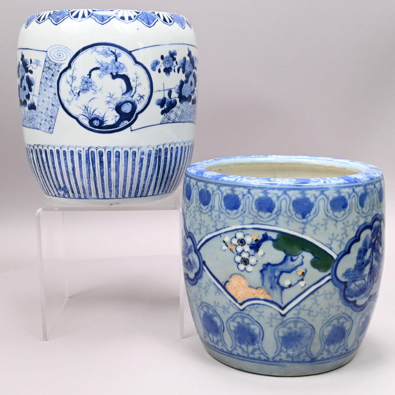 Two Japanese Blue and White Porcelain Hibachis: Two Japanese Blue and White Porcelain Hibachis. The first reserved with prunus branch fan and landscape cartouches, the second with prunus branch quatrefoils and flowering aster scrolls, both within