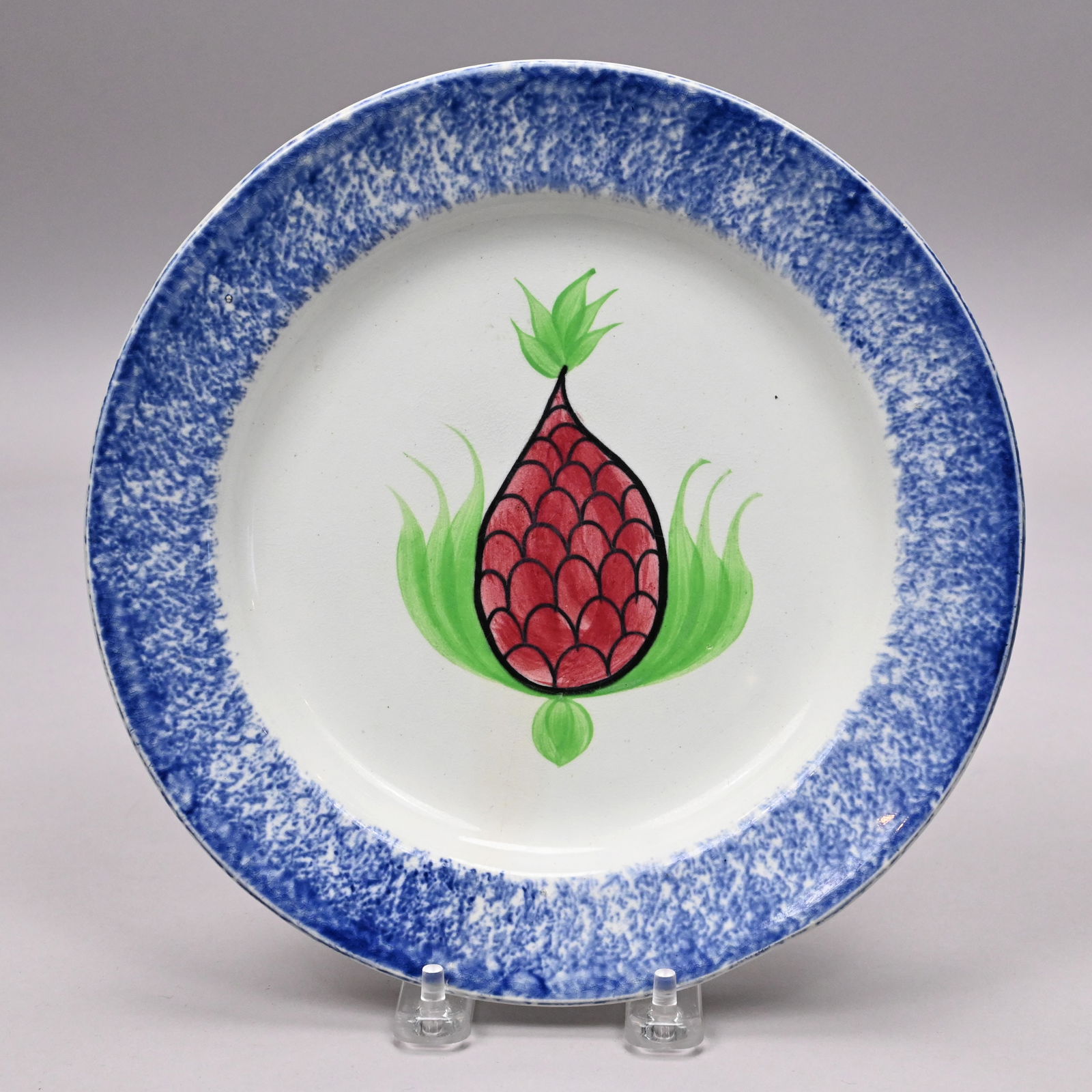 British Spatterware and Painted 'Pineapple' Plate: British Spatterware and Painted 'Pineapple' Plate, 1830-1850. Painted in the center with a pineapple in red, green and black enamels, within a sponged blue rim.H: 1.125 in., Diam: 9.125 in.
