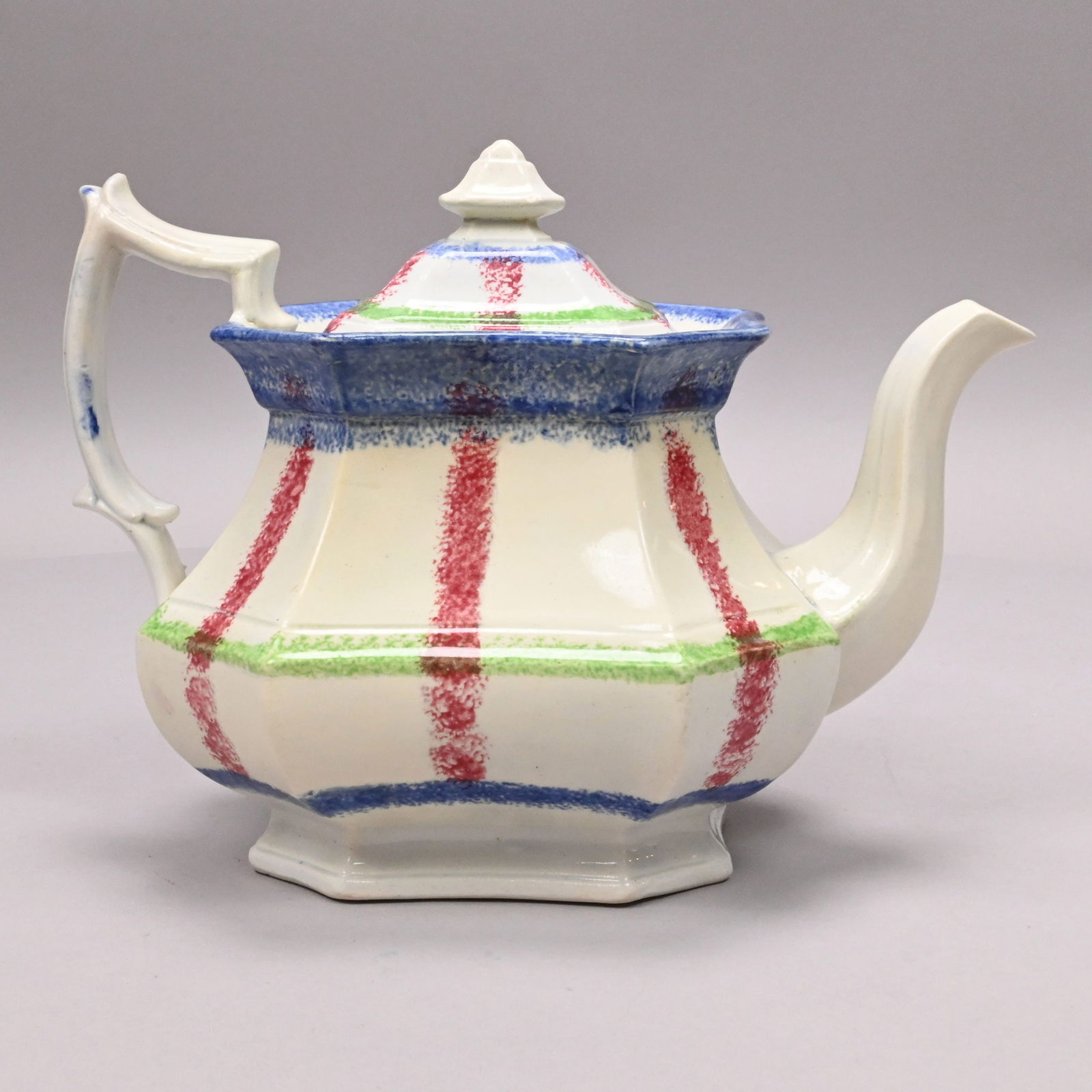 British Spatterware Rainbow Plaid Teapot and Cover: British Spatterware Rainbow Plaid Teapot and Cover, Mid-19th Century. Stick sponged with criss-crossed lines in red, blue and green, unmarked.H: 7 in., W: 10 in., D: 5.875 in.