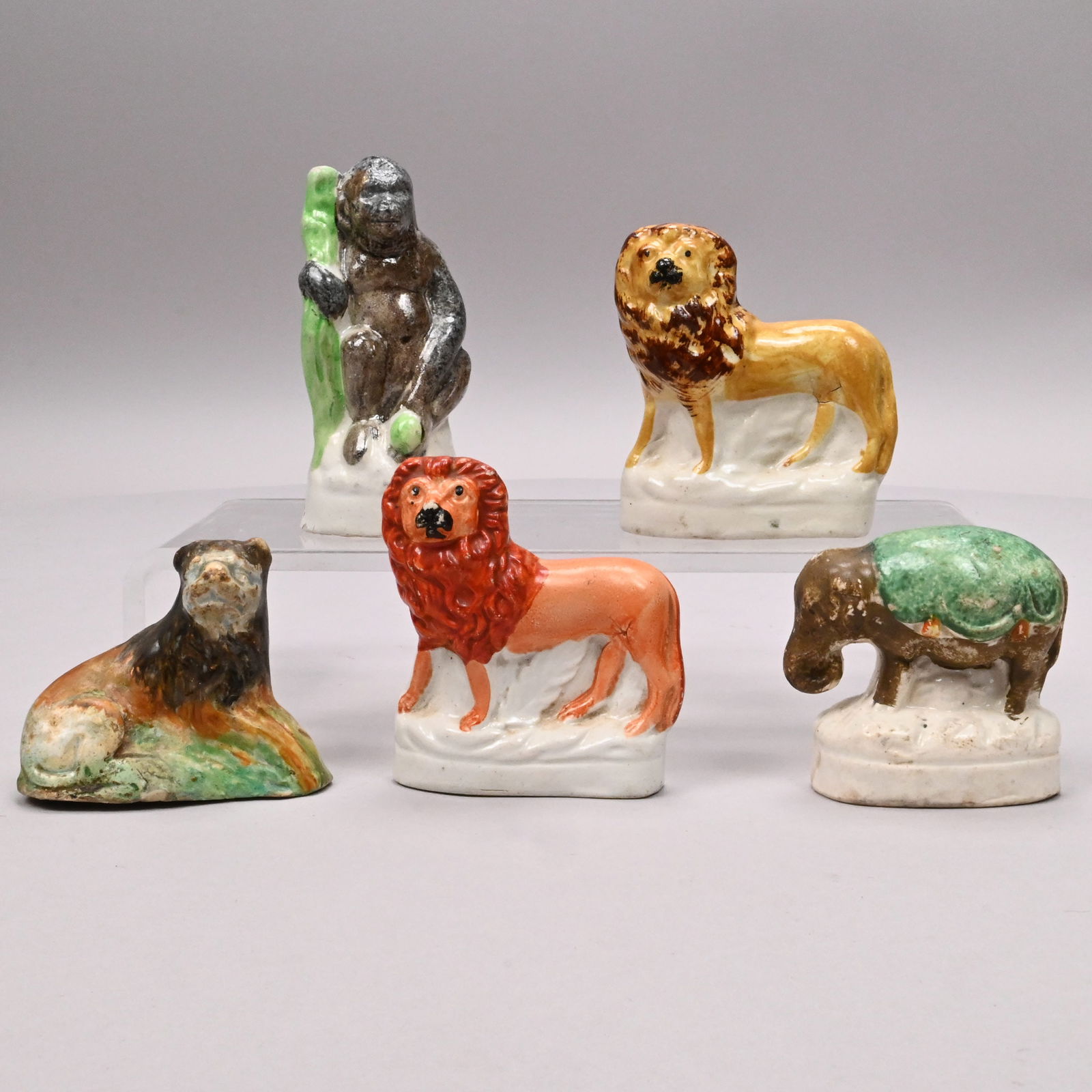 Five Staffordshire Pottery Wild Animals: Five Staffordshire Pottery Figures of Wild Animals, 1790-1860. Comprising a recumbent lion, two standing lions, a gorilla and an elephant.Gorilla: H: 4.125 in., W: 1.875 in., D: 1.625 in.