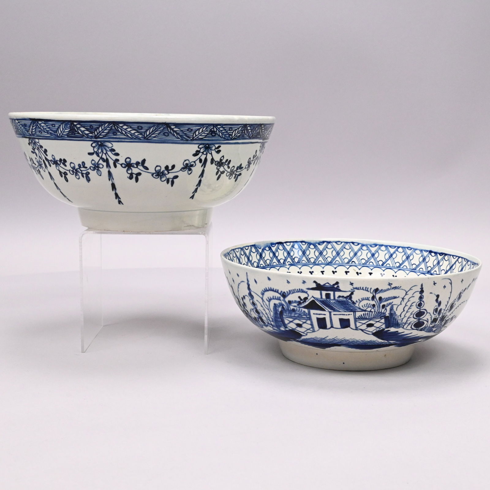 Two English Pearlware Blue and White Bowls: Two English Pearlware Blue and White Bowls, 1790-1805. The first painted in chinoiserie style with a garden view on the interior, the rim surrounded by a trellis diaperwork border, and on the