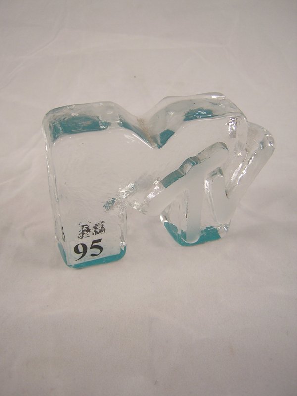 Crystal MTV logo, 3.5" long. The "tv" has a satin f: Crystal MTV logo, 3.5" long. The "tv" has a satin finish, and there is turquoise paint on the bottom legs of the M (this creates a colorful look when the logo is upright).