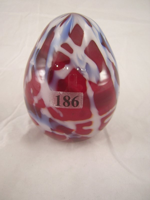 Robert Barber Egg: This 4.5" tall Barber egg is re: Robert Barber Egg: This 4.5" tall Barber egg is red with white and light blue wide threading. This egg has the Fenton oval logo and 1976.