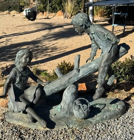 Life Size Bronze boy and girl on a log