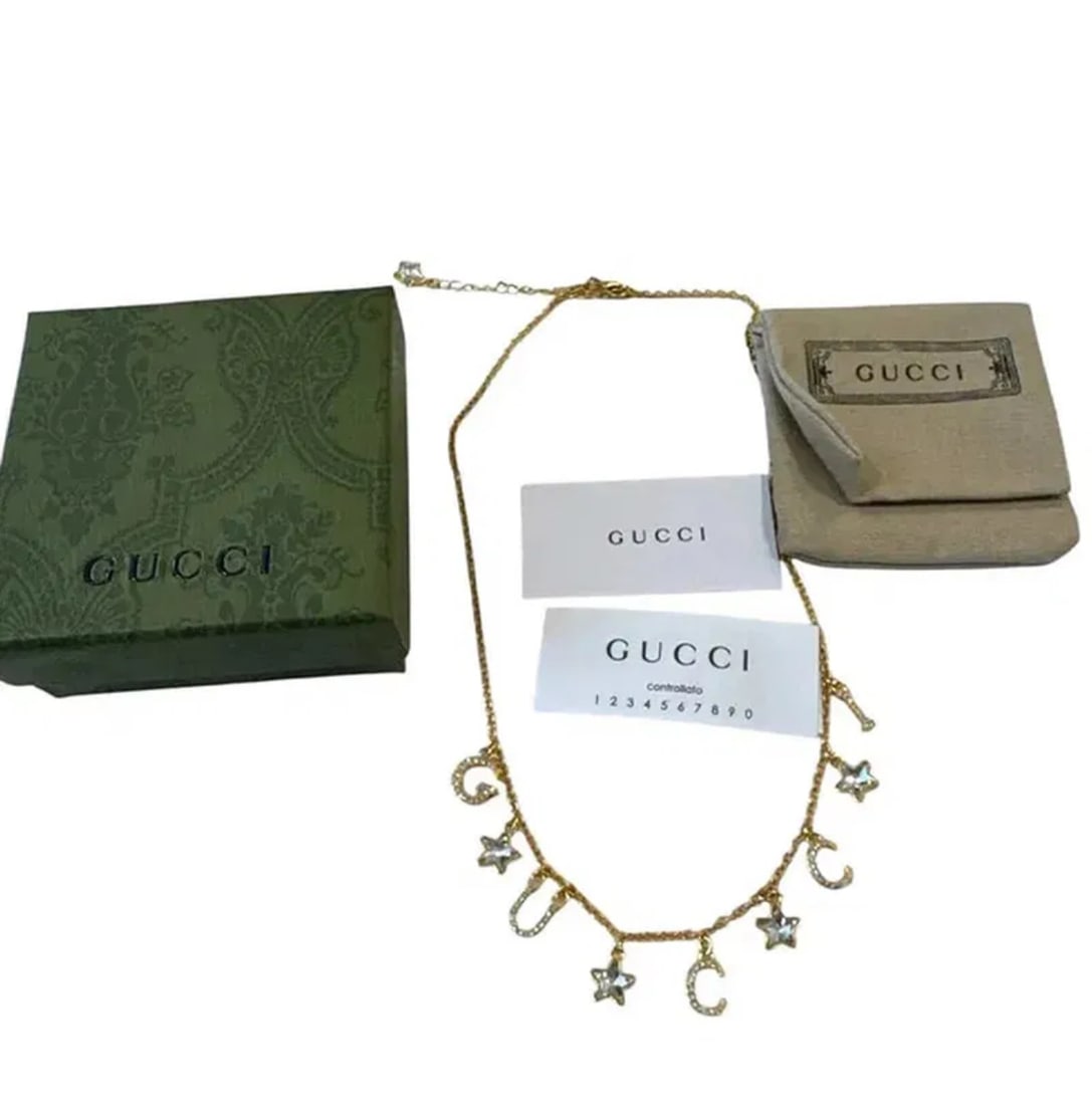 GUCCI Gucciscript gold-tone brass crystal and glass necklace: Includes box and certificate. Shipping only .