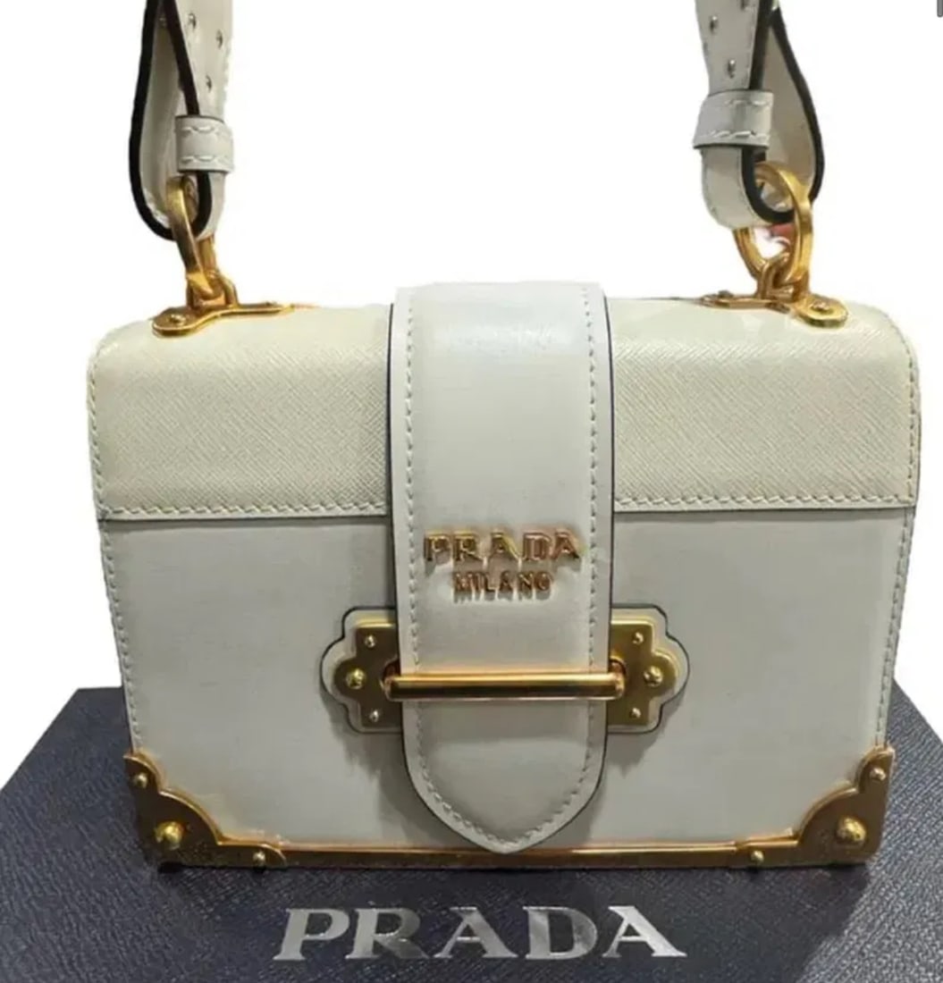 Prada Cashier White Leather Crossbody Bag: Size: Base length: 7.00 inHeight: 5.00 inWidth: 2.00 inDrop: 20.50 in - Includes box and Dust Bag. Shipping only.