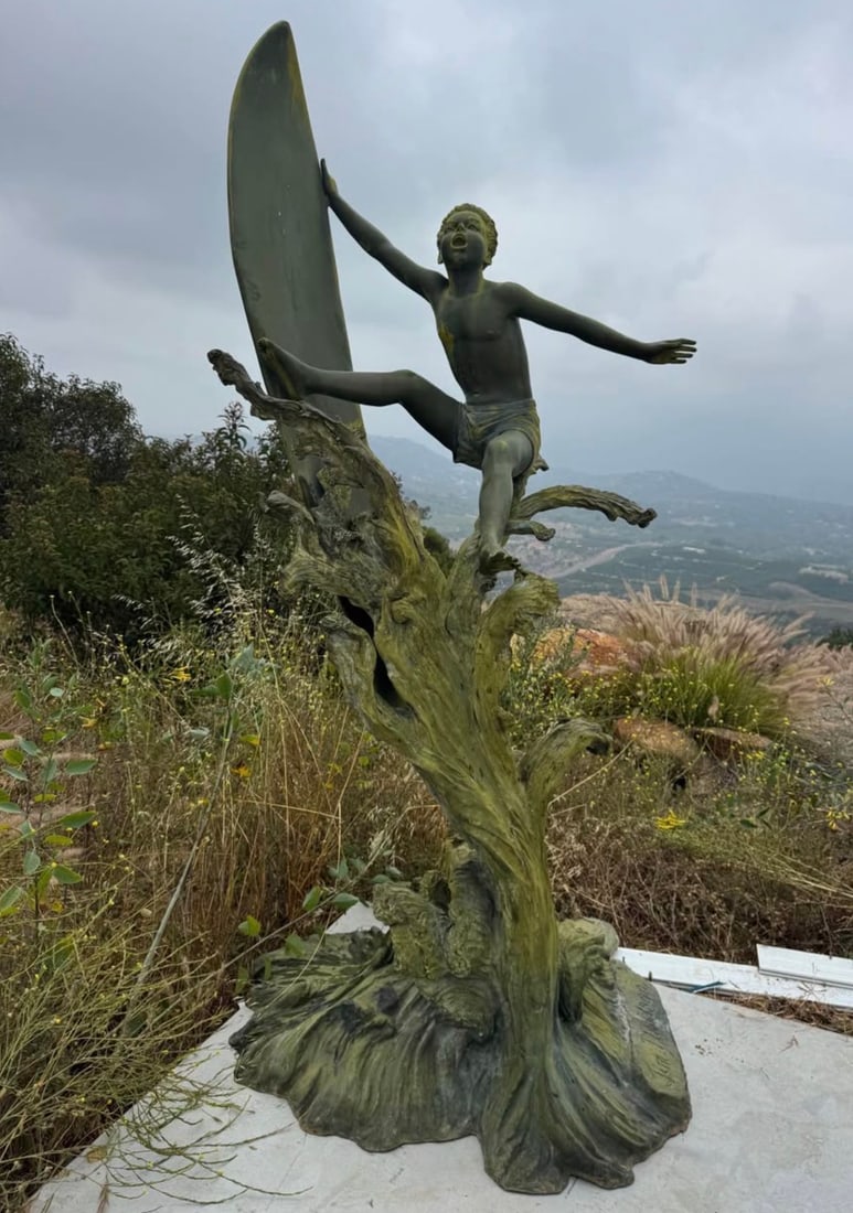 Life Size Bronze Sculpture Surfer Boy Statue by Jim Davidson: Artistic surfer boy statue. Statue has boy in surfing pose, holding surfboard. Mounted on base resembling tree roots. Signature 'Jim Davidson' on base.120” inches tall