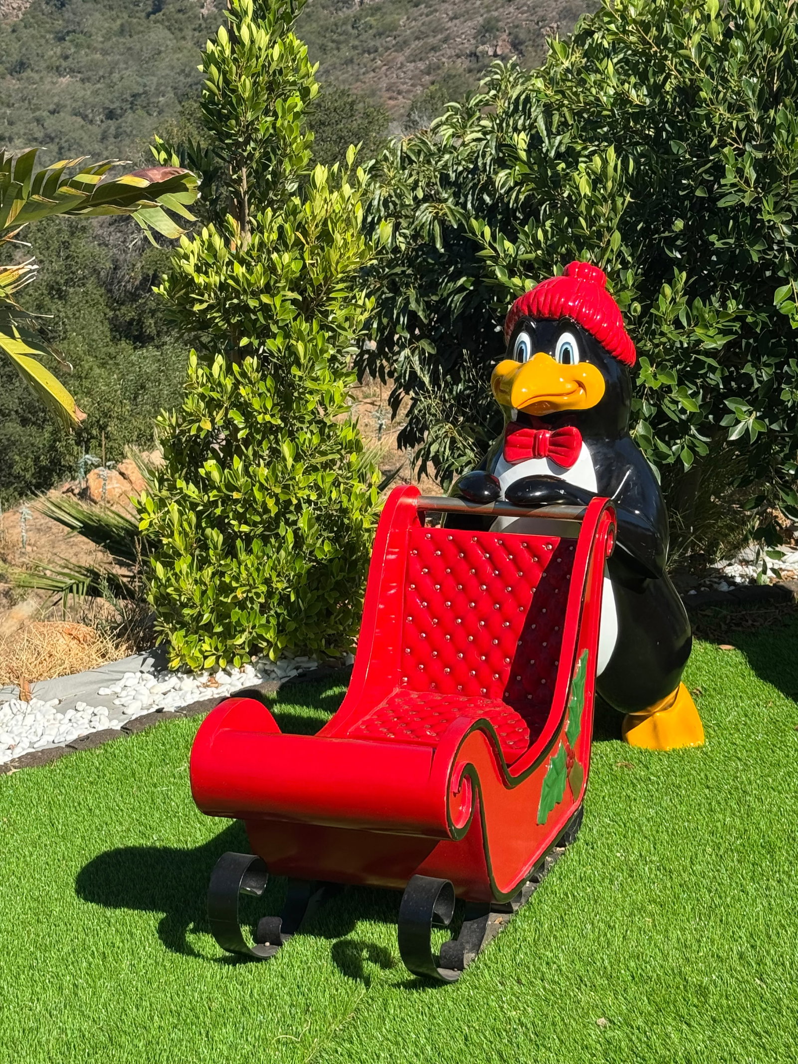Life-Size Fiberglass Penguin with Christmas Sleigh Holiday Decor: size: 60” x 43 in H Durable fiberglass holiday display features a large penguin wearing a red knit hat and bow tie pushing a red sleigh. The sleigh has a tufted red interior and holly leaf accen