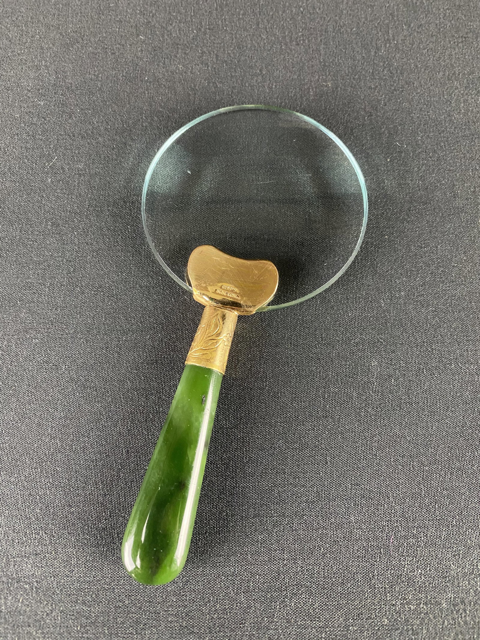 Gumps San Francisco Nephrite handled Magnifying Glass: Gumps of San Francisco Nephrite jade handled Magnifying glass. The Jade has a beautiful deep green color. The lens has several scratches consistent with age. The piece measures 5 1/8 inches long and 2