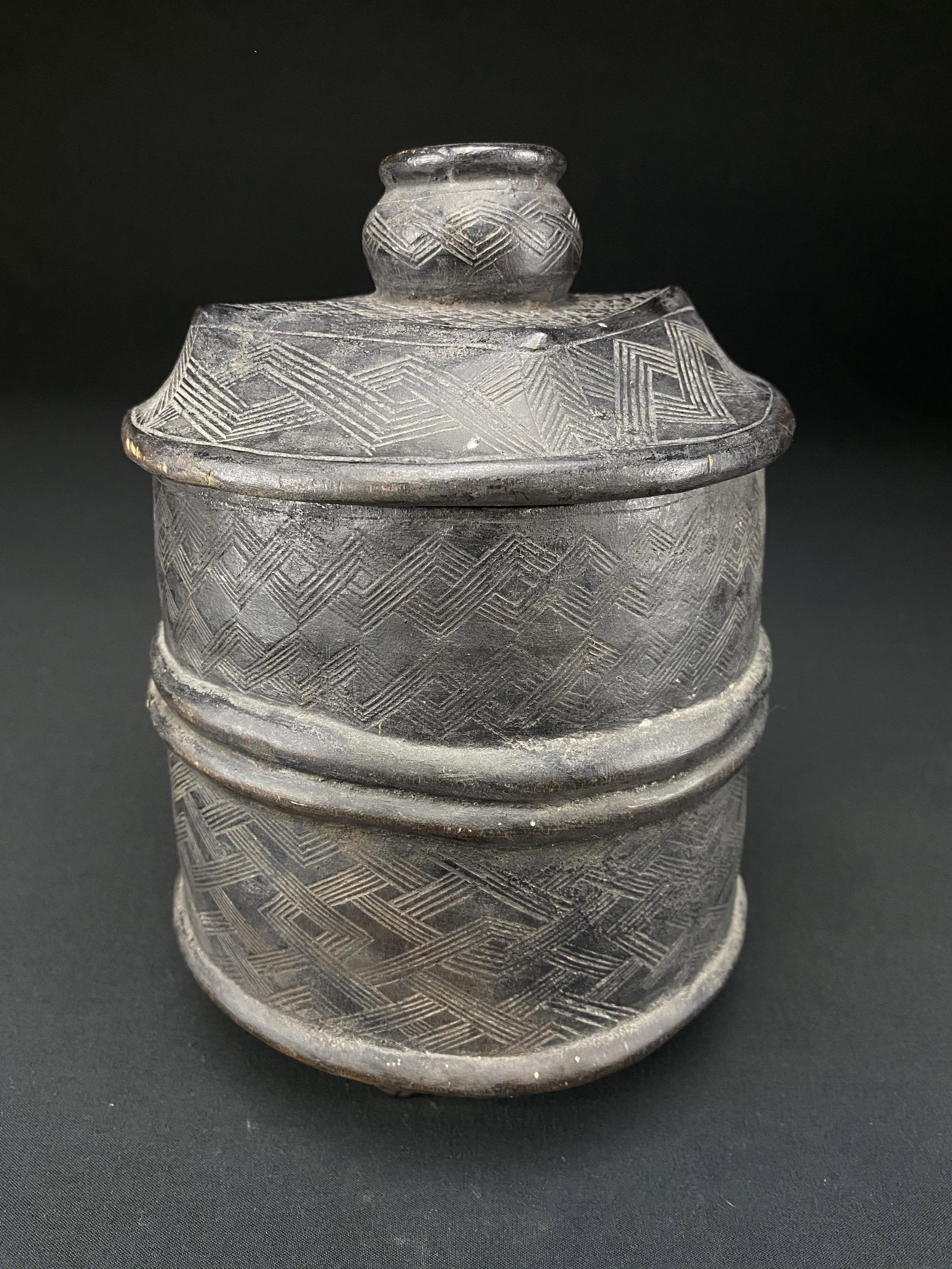 Antique Kuba Carved Wood lidded Camwood 'Basket' Box: Antique Kuba carved wood lidded 'Basket' vessel Mbala group. This vessel has a unique additional carved vessel as the lids handle. There is a beautiful maroon colored patina. The inside of the contain