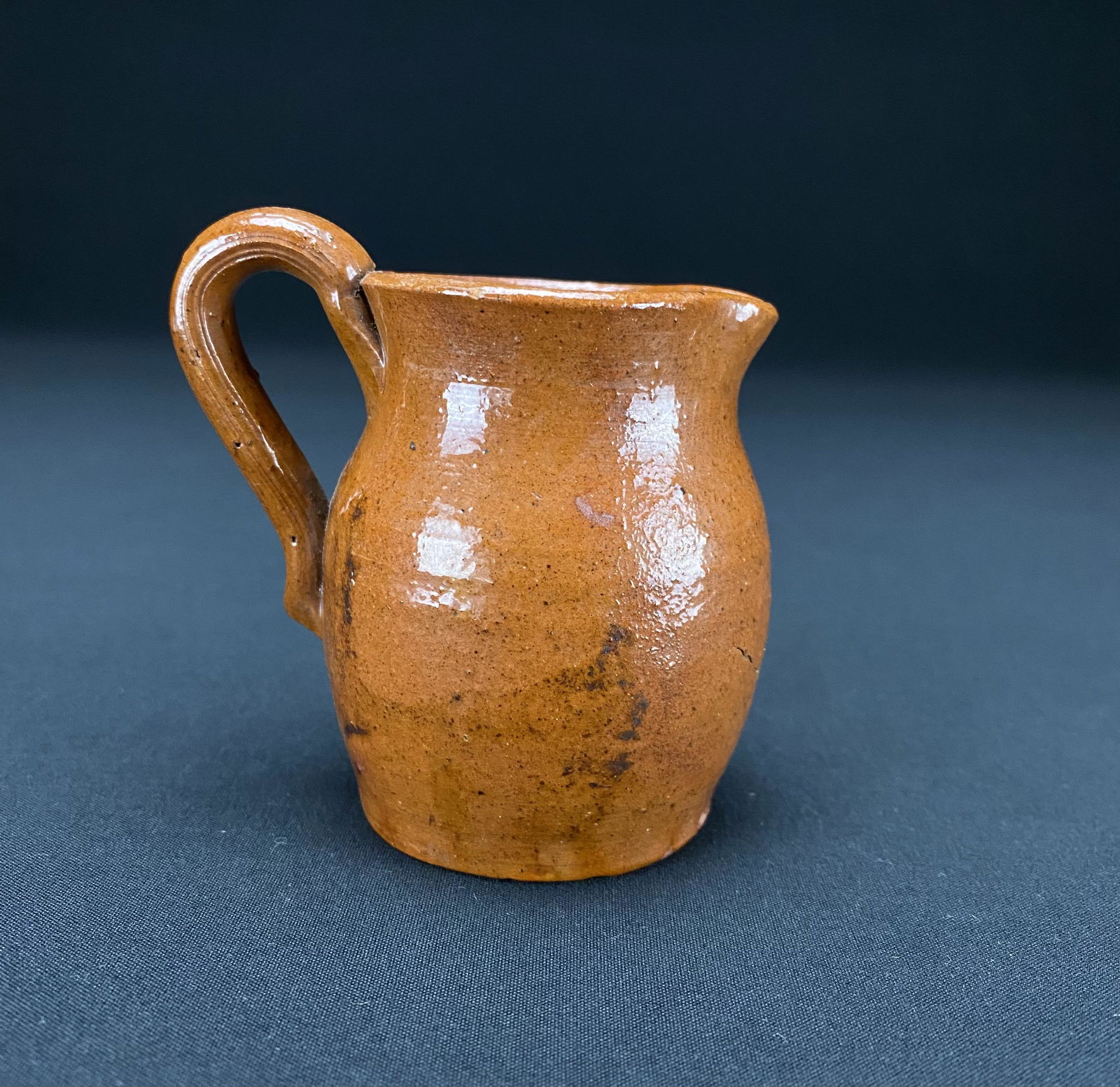 W.W. Cline Hartford City Indiana Redware Pitcher 1906: W.W. Cline of Hartford Indiana Redware Pitcher dated 1906. The Pitcher has an incised signature and date on the bottom. There are two small chips otherwise in good condition for age. It measures 3 3/8