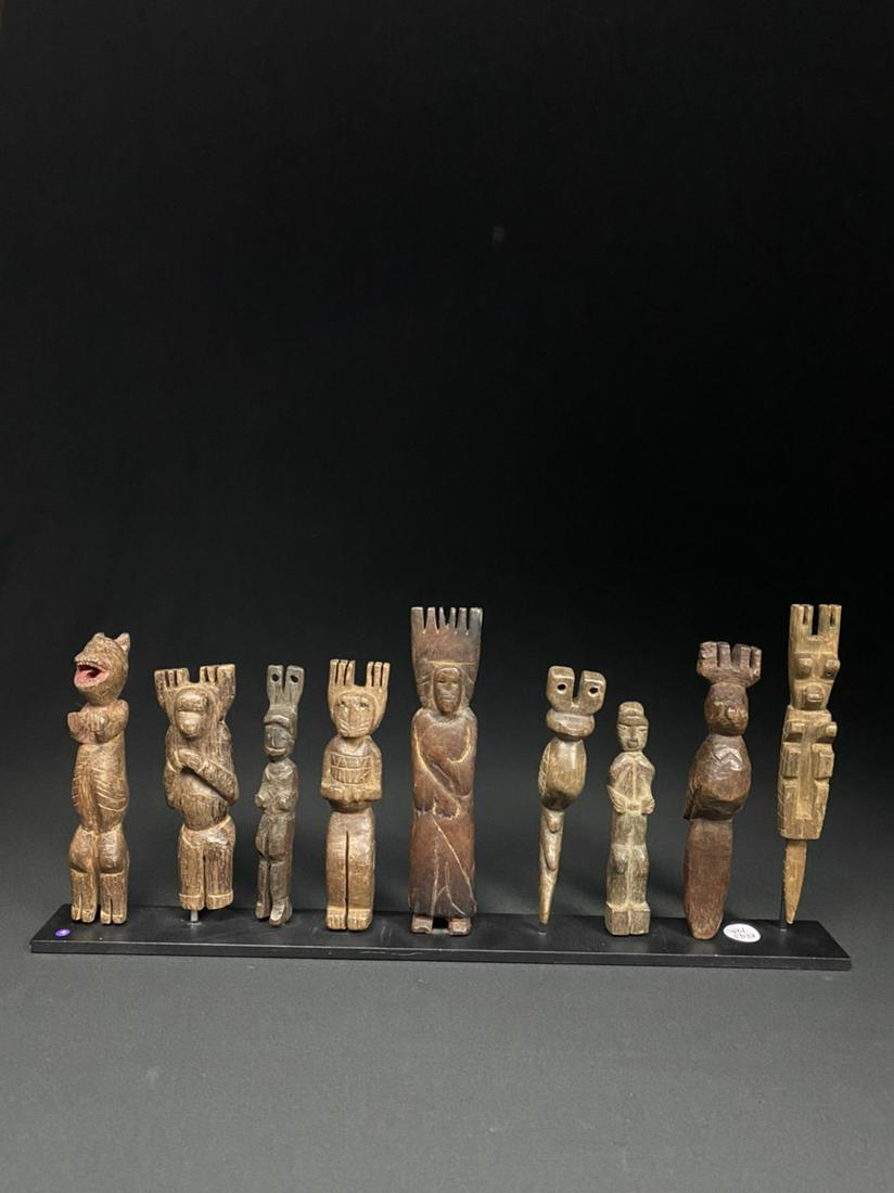 Lot of 9 Guatemalan folk art sling shots: A collection of 9 hand-carved Guatemalan ethnographic slingshots, professionally mounted on a black metal base. Assortment comprised of varying figural types, and ages.