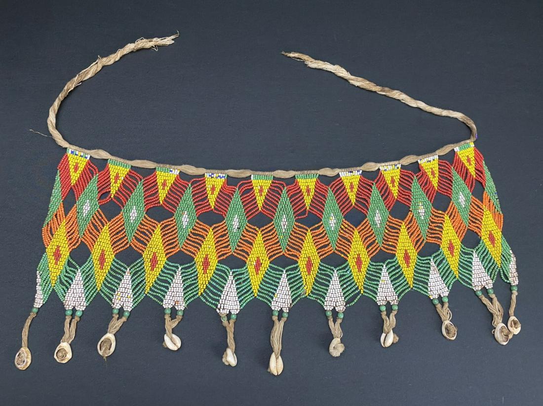 A Vintage African Modesty Belt: A beaded Cache Sexe, enhanced with cowrie shells. Traditionally worn by the Kirdi women of Cameroon, such belts were outlawed in recent times in favor of Western dress.